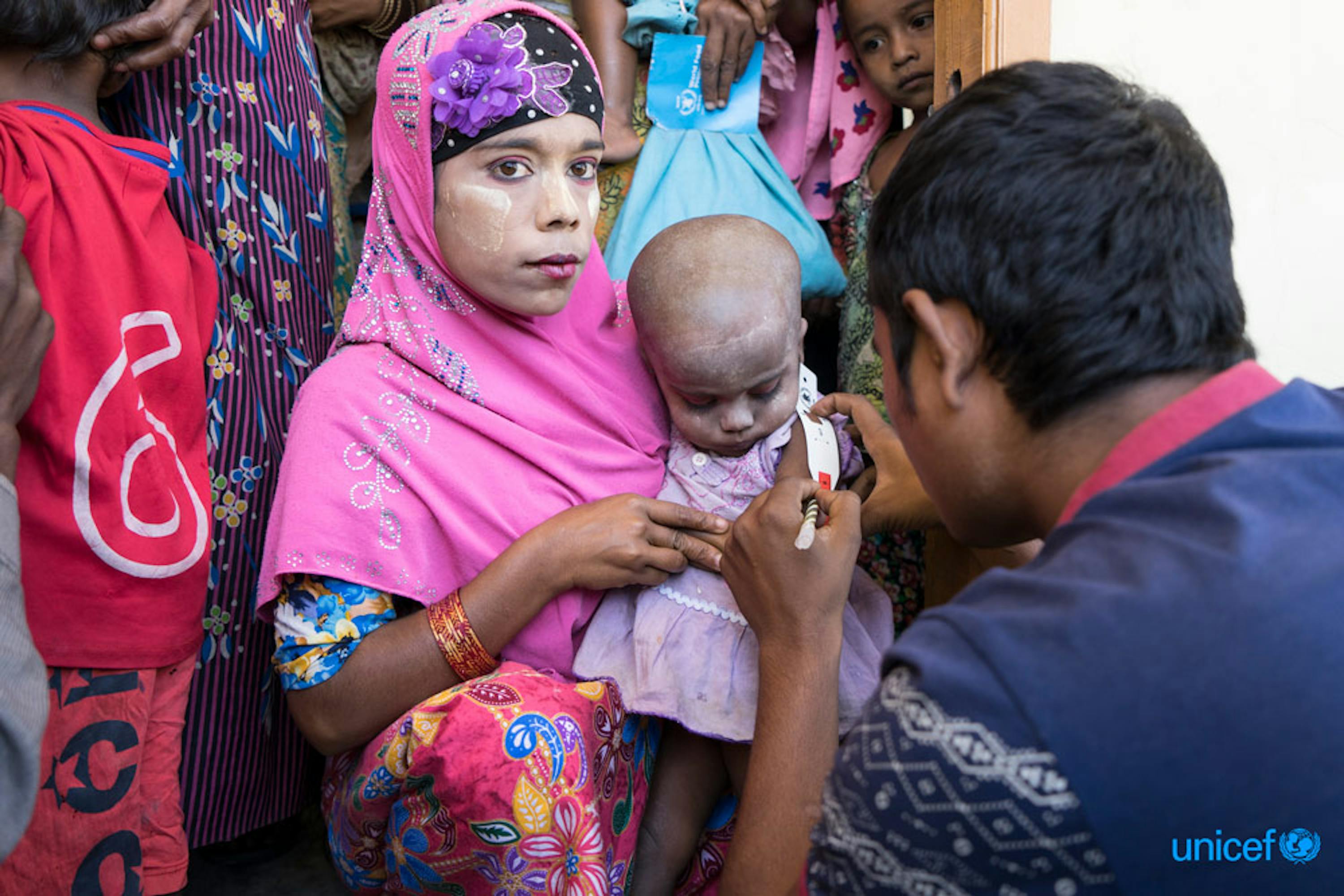 Nel centro nutrizionale del villaggio di Thae Chaung (zona centrale dello stato di Rakhine, in Myanmar) una bambina in braccio alla sua mamma viene monitorata per controllare il suo stato nutrizionale - ©UNICEF/UN0155430/Thame