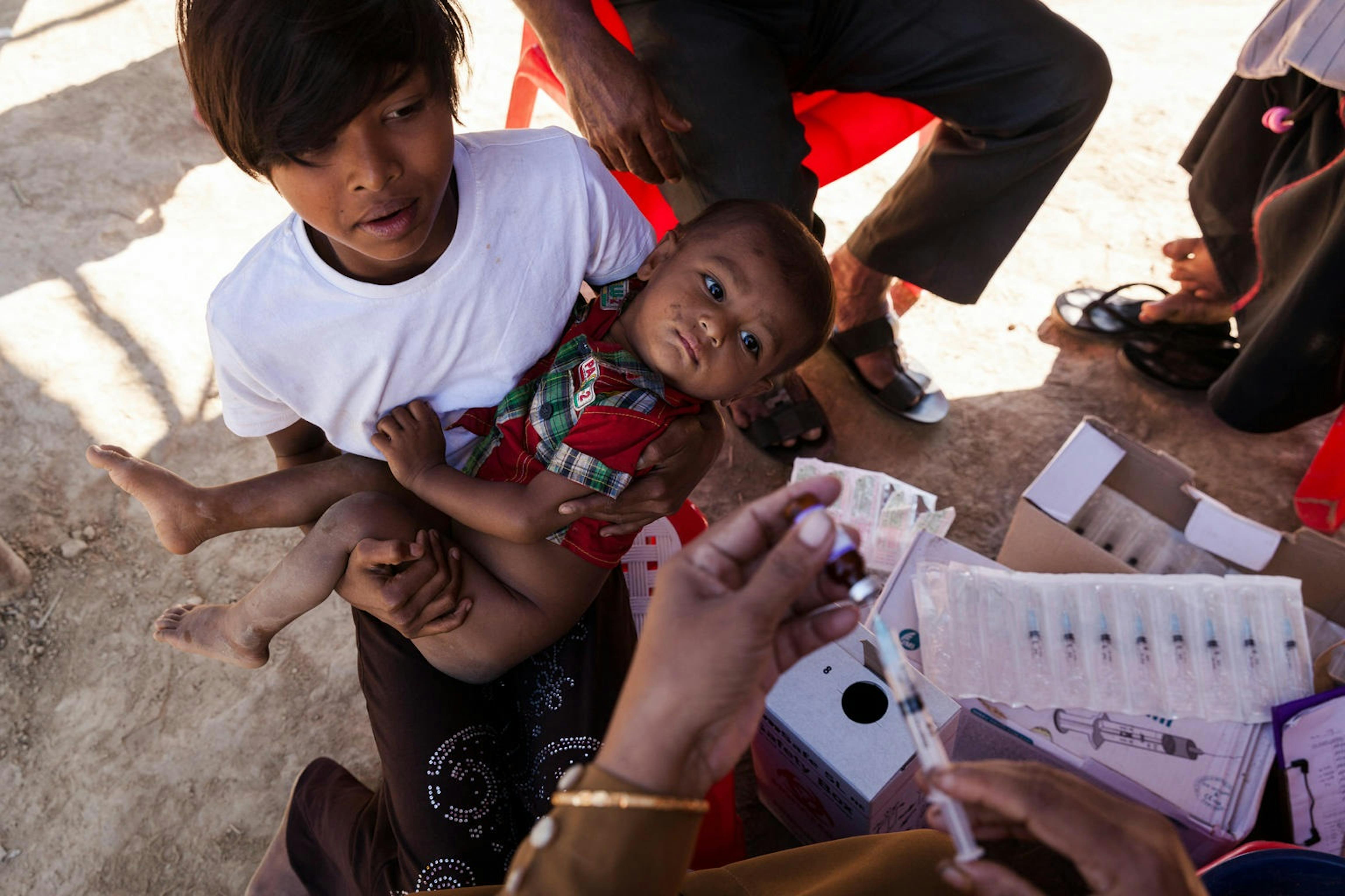 Una giovane mamma porta il suo bambino alla vaccinazione contro il morbillo, in un campo profughi a Cox's Bazar (Bangladesh) -  ©UNICEF/UN0149110/Brown