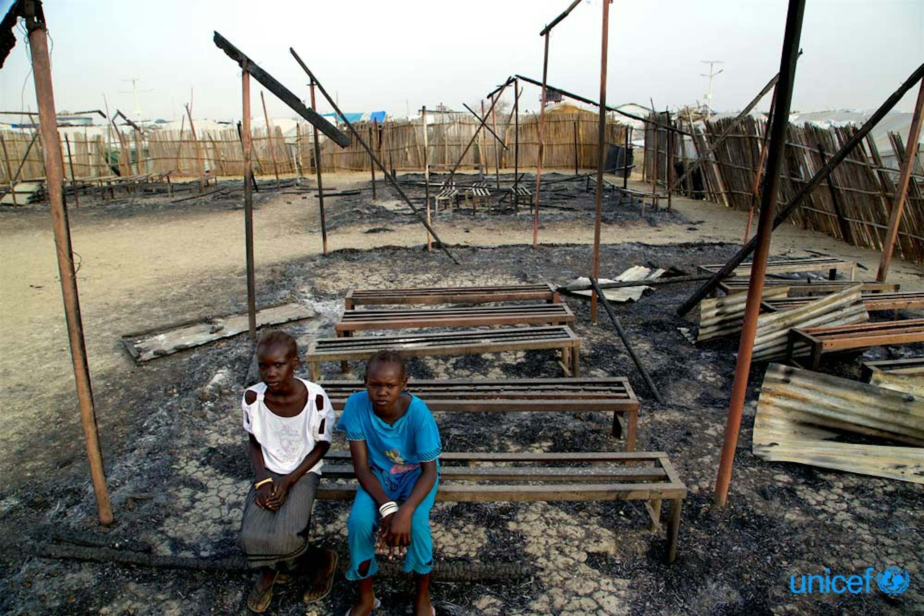 Due bambini fra le rovine bruciate della loro scuola a Malakai, Sud Sudan - © UNICEF/UN018992/George