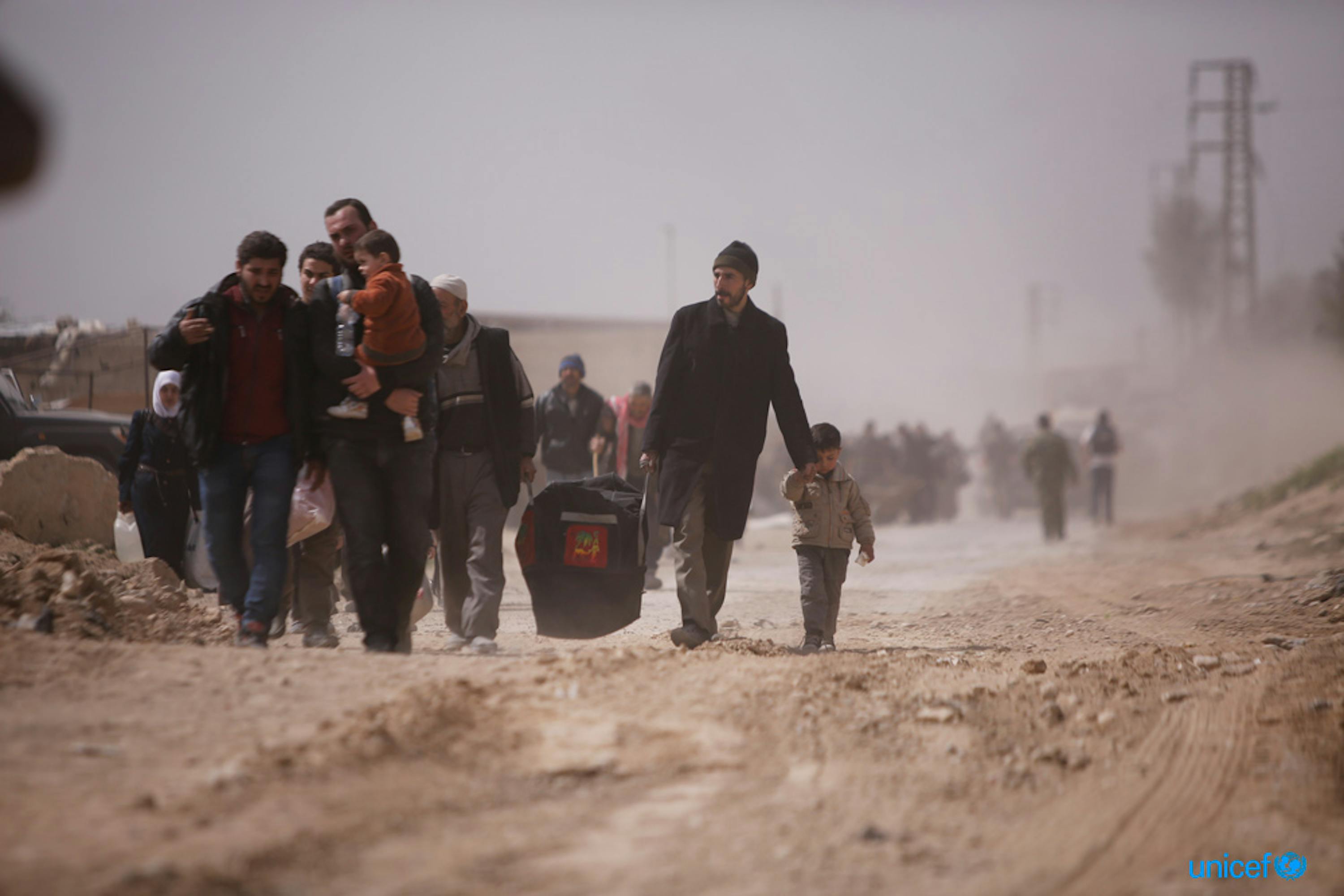 Alcune famiglie camminano verso Hamourieh dove è stato aperto un varco per lasciare la regione del Ghouta orientale, © UNICEF/UN0185410/Sanadiki