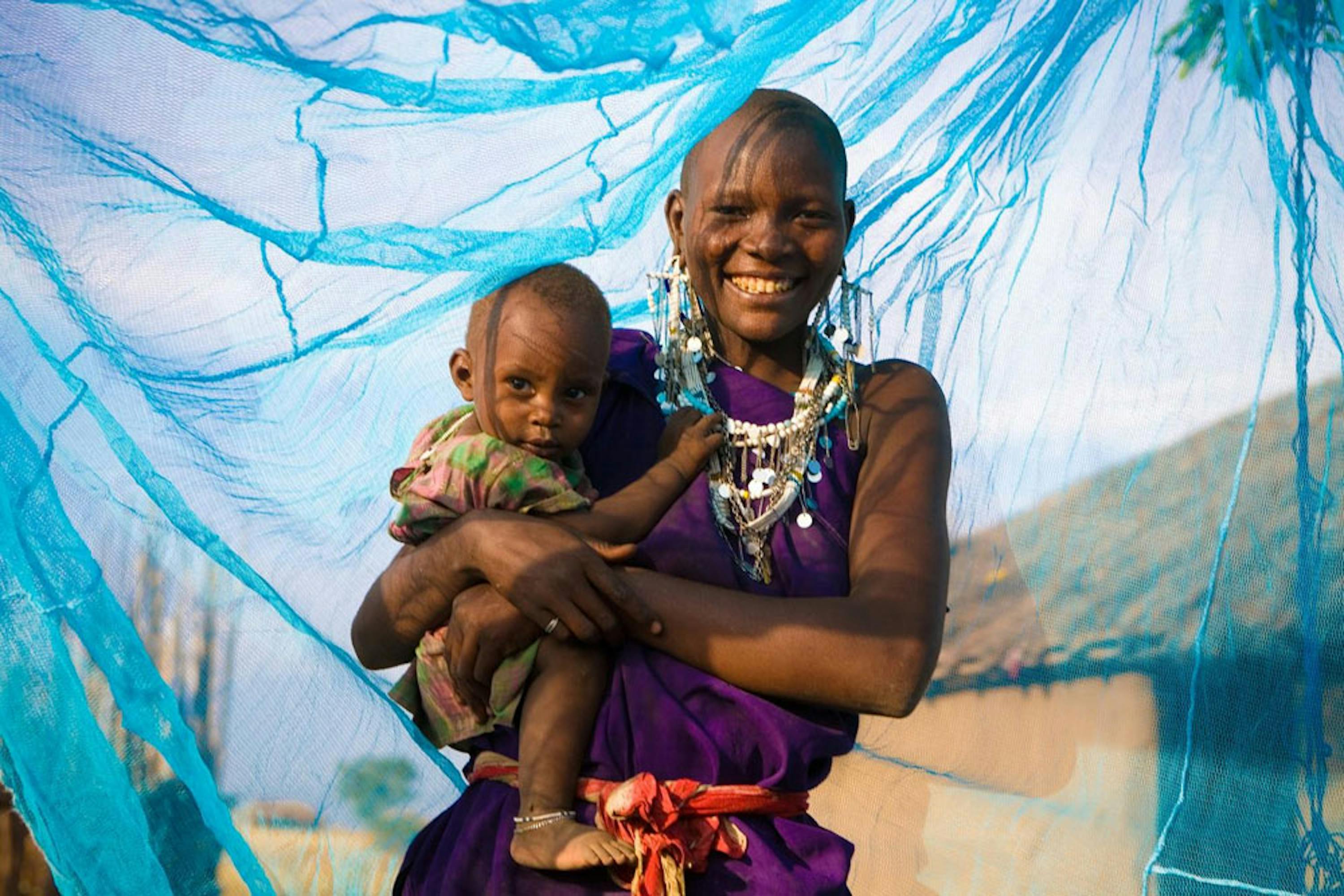 Madre e bambino sotto una zanzariera trattata con insetticida ad Arusha, Tanzania - ©UNICEF/UNI174121/Hallahan