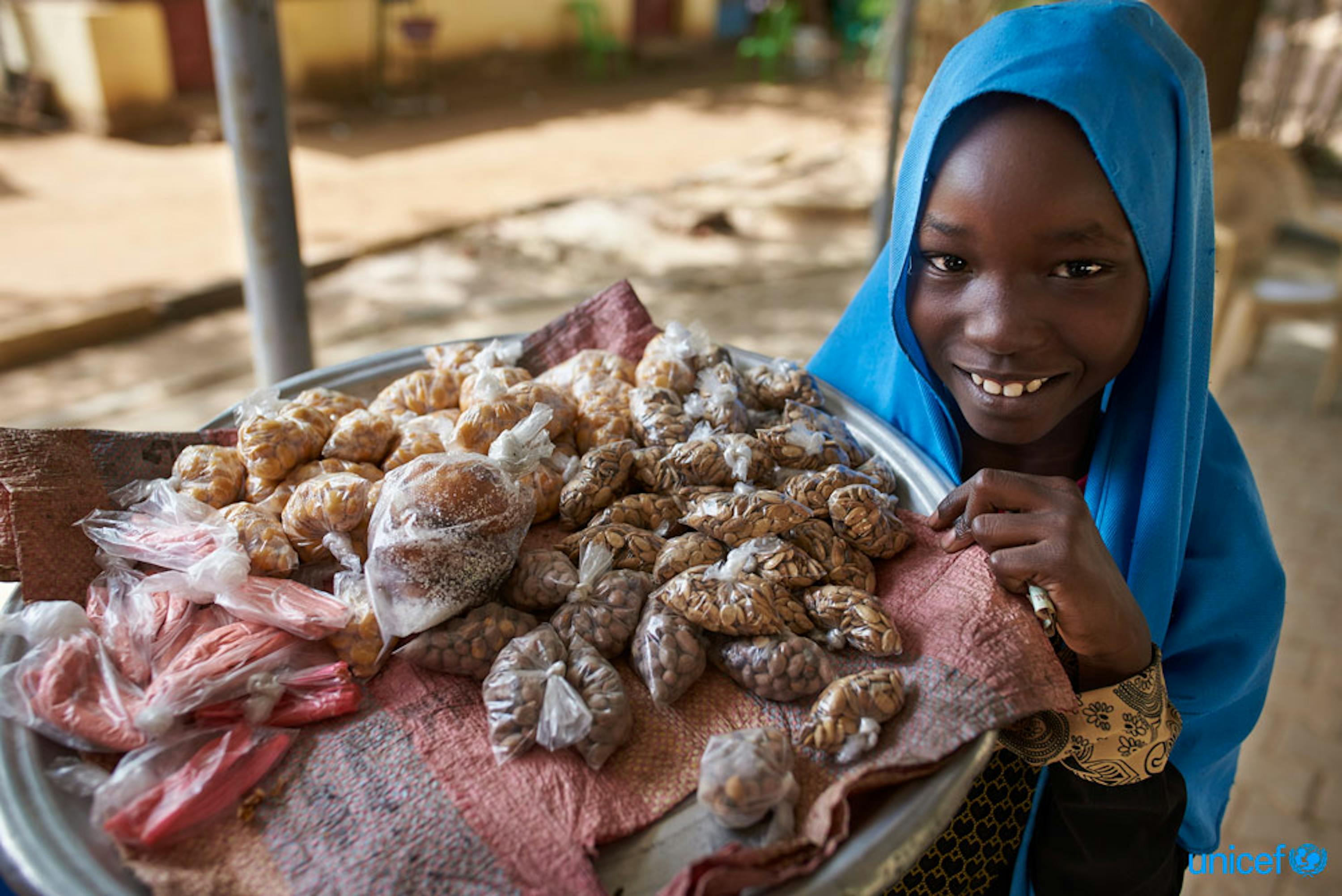 Una bambina vende snacks nella città di Kaduli, Sudan - © UNICEF/UN0211173/Noorani