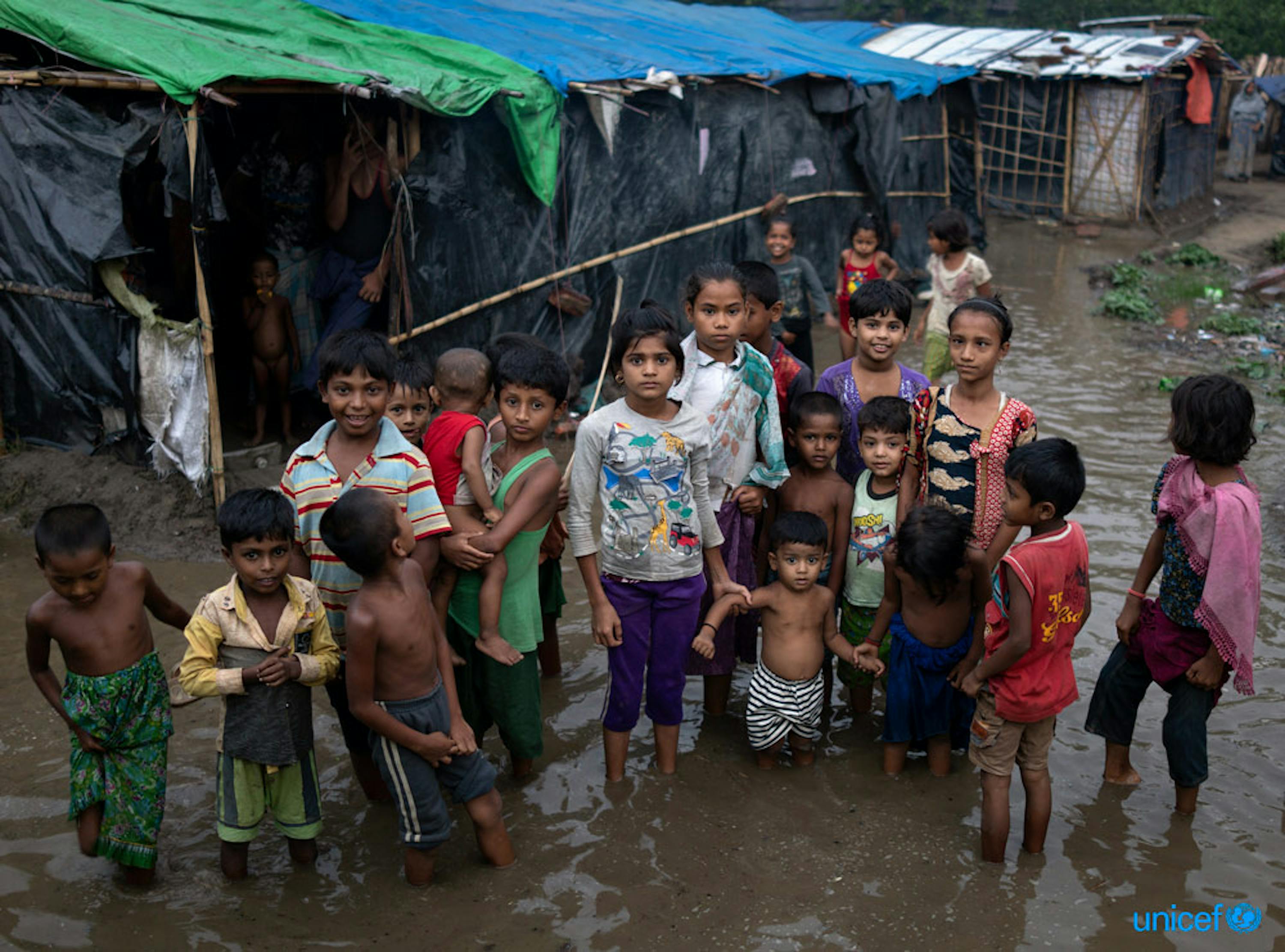 Alcuni bambini rohingya guadano le acque che circondano il loro campo di Cox Bazar dopo una pioggia intensa portata dai monsoni - © UNICEF/UN0213967/Sokol