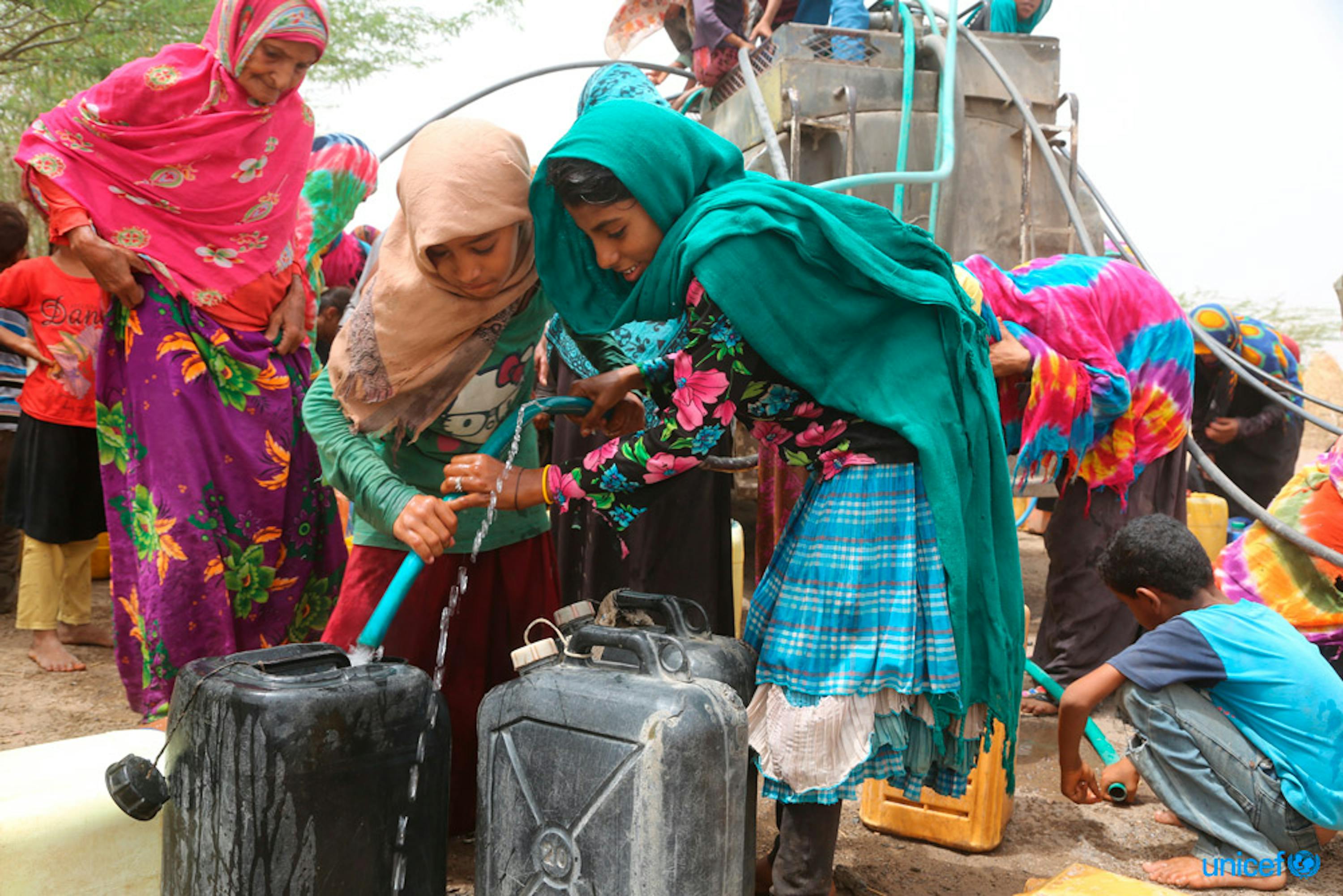 Yemen, donne e bambini riempiono le taniche d'acqua - © UNICEF/UN0216971/Ayyashi