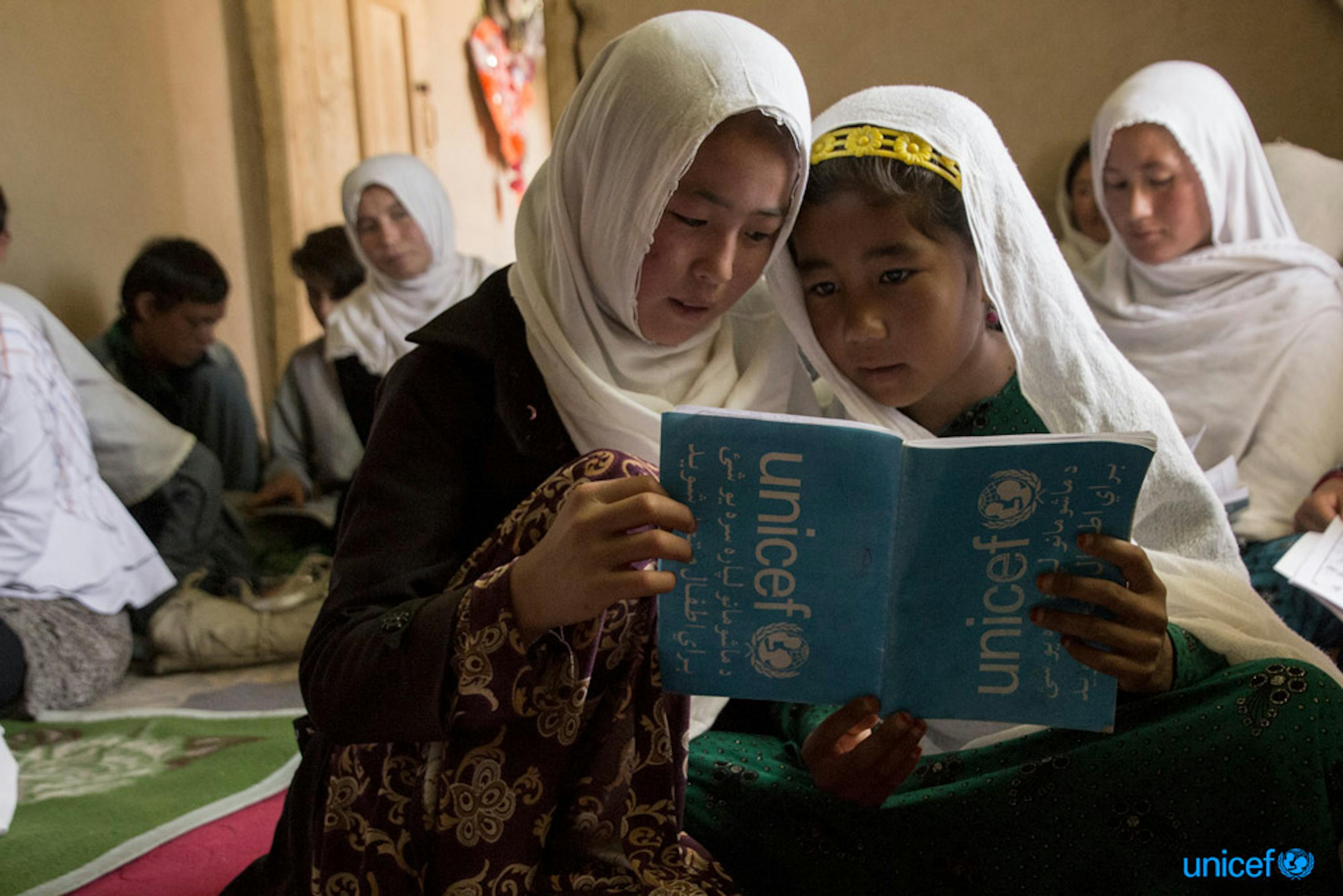 Due ragazze leggono il loro libro di testo durante una lezione nell' Accelerated Learning Centre (ALC) di Sharak e Muhajireen, Afghanistan -  © UNICEF/UN0211158/Rezayee