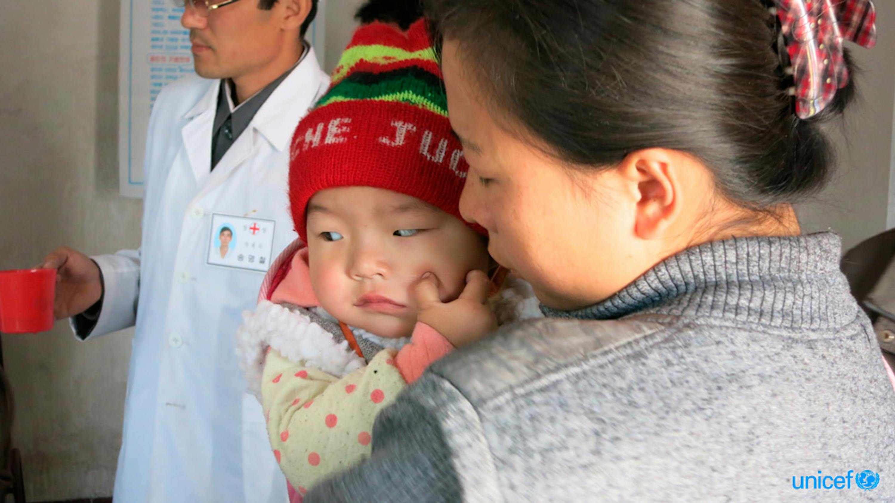 Una mamma e il suo bambino in attesa del loro turno per ricevere il supplemento di Vitamina A e Vermifughi - © UNICEF/UNI180565/Basurmanova