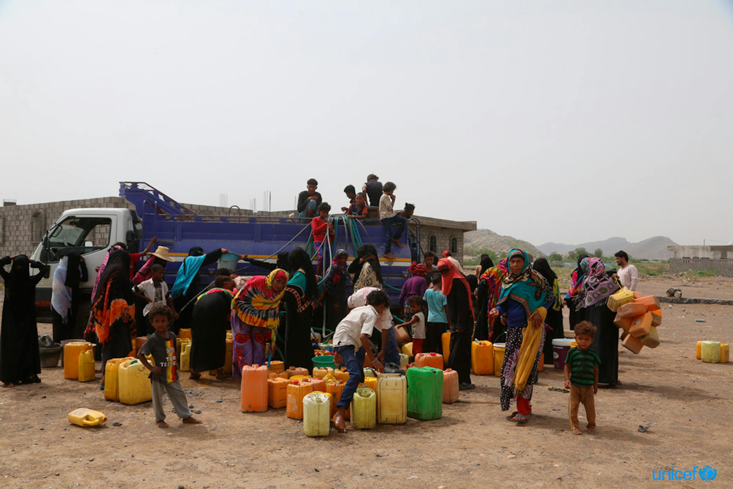 Yemen, donne e bambini riempiono taniche di acqua nel distretto Bajel di Hodeidah dove l'acqua scarseggia. © UNICEF / UN0216972 / Ayyashi