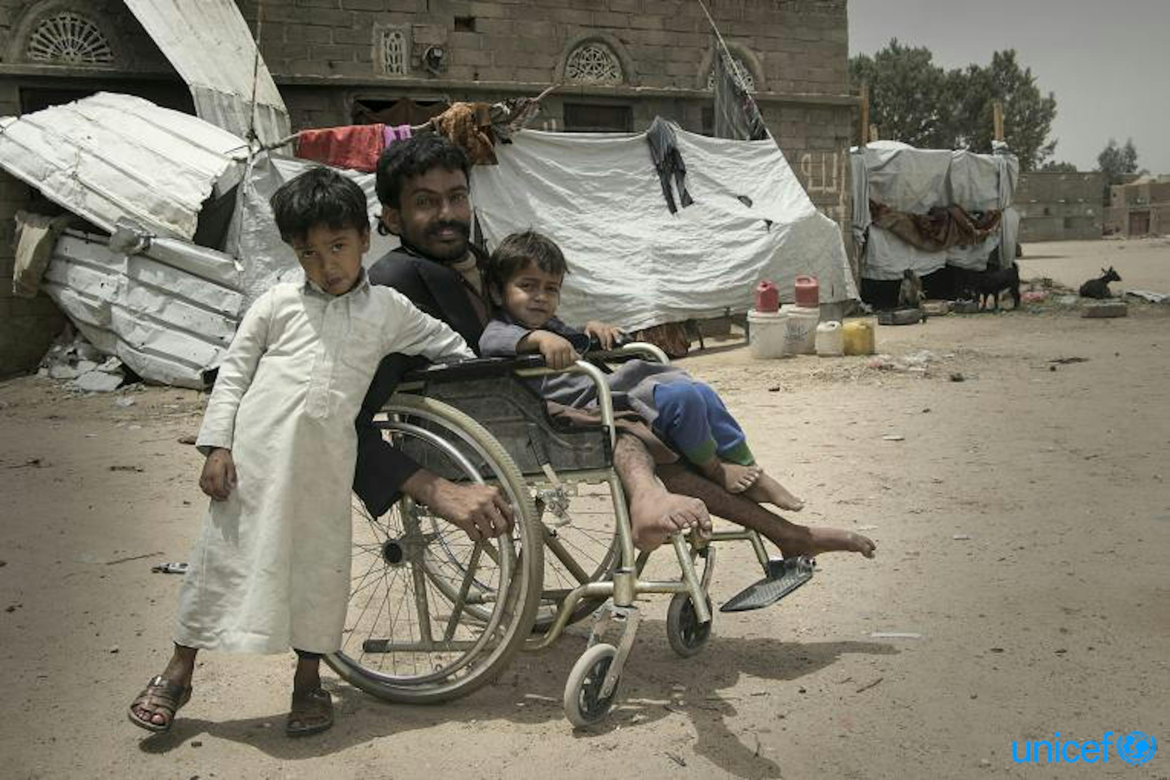 Saleh Saleh Al-Shami con due dei suoi quattro figli. Ha smesso di ricevere stipendi sul suo lavoro tre anni fa, e ora i trasferimenti di denaro lo aiutano a comprare cibo per la sua famiglia. © UNICEF Yemen/2018/Gabreez