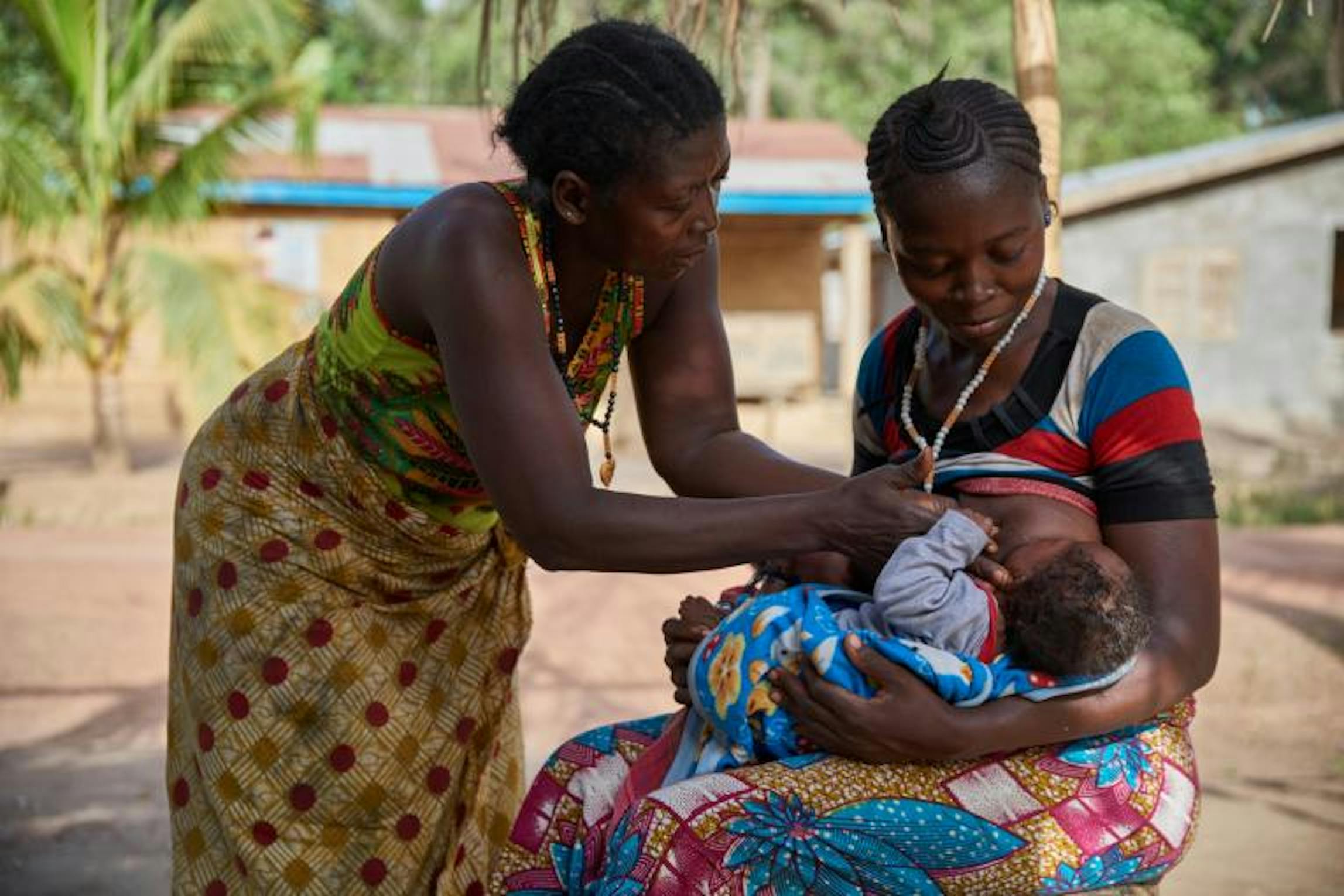 Zainab Kamara, sostenuta da sua madre, allatta uno dei suoi due  gemelli di 3 mesi - © UNICEF/UN065254/