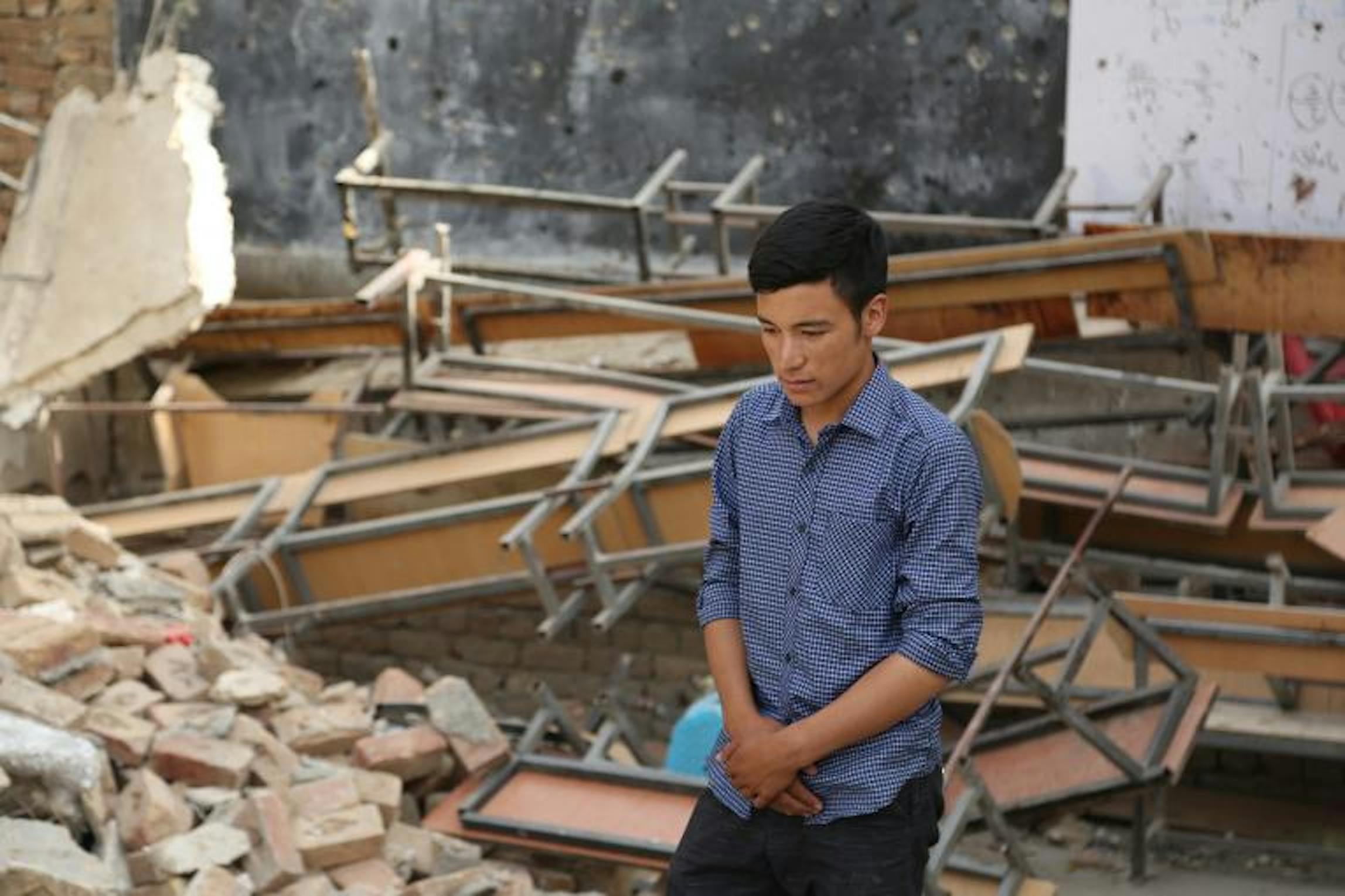 Un ragazzo in una scuola distrutta dai combattimenti - © UNICEF/Afghanistan