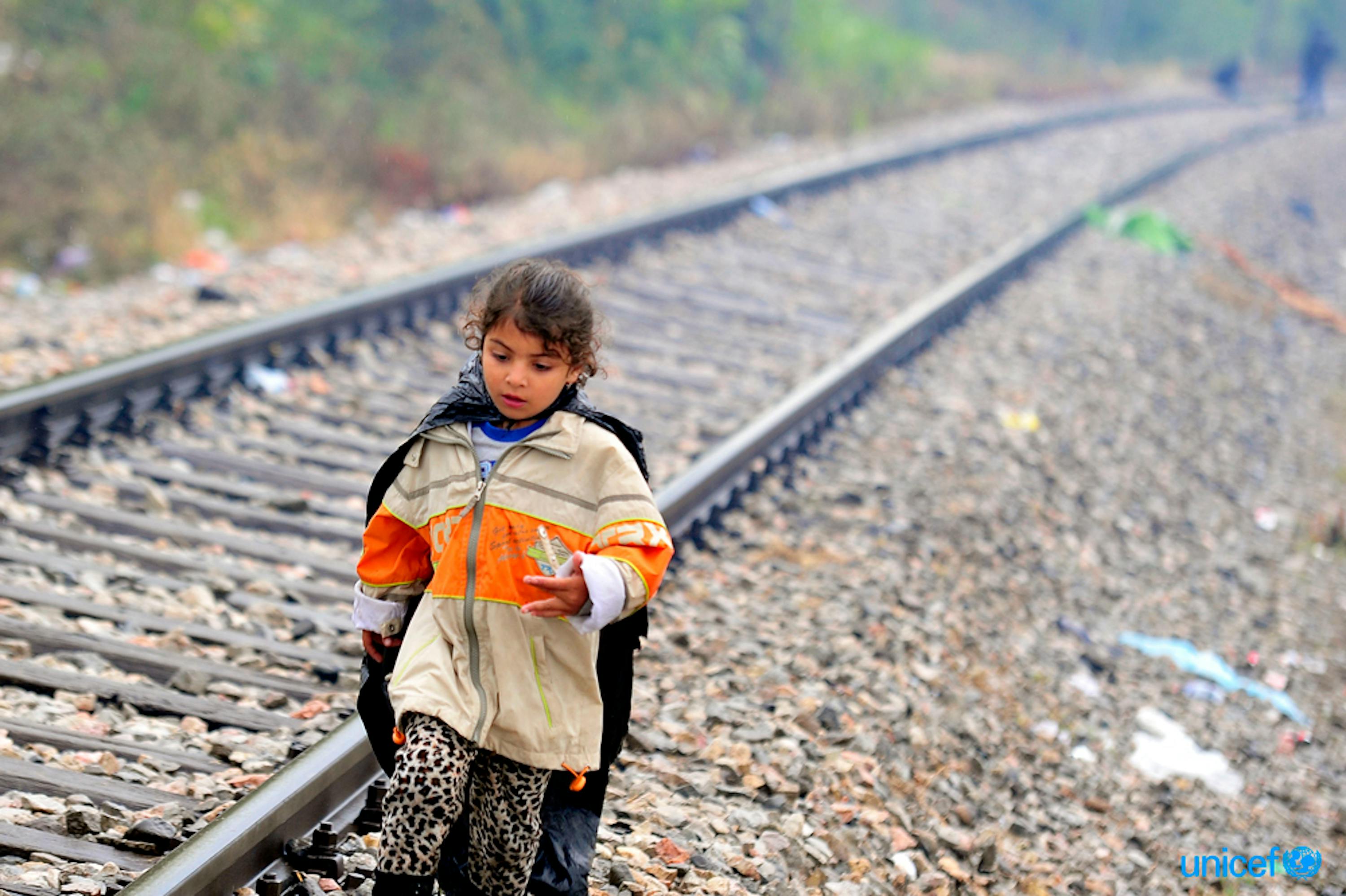 una bambina siriana cammina lungo i binari della ferrovia al confine tra Grecia ed ex repubblica jugoslava di Macedonia durante l’esodo di massa del 2015 lungo la rotta balcanica - ©UNICEF/UNI196239/Georgiev