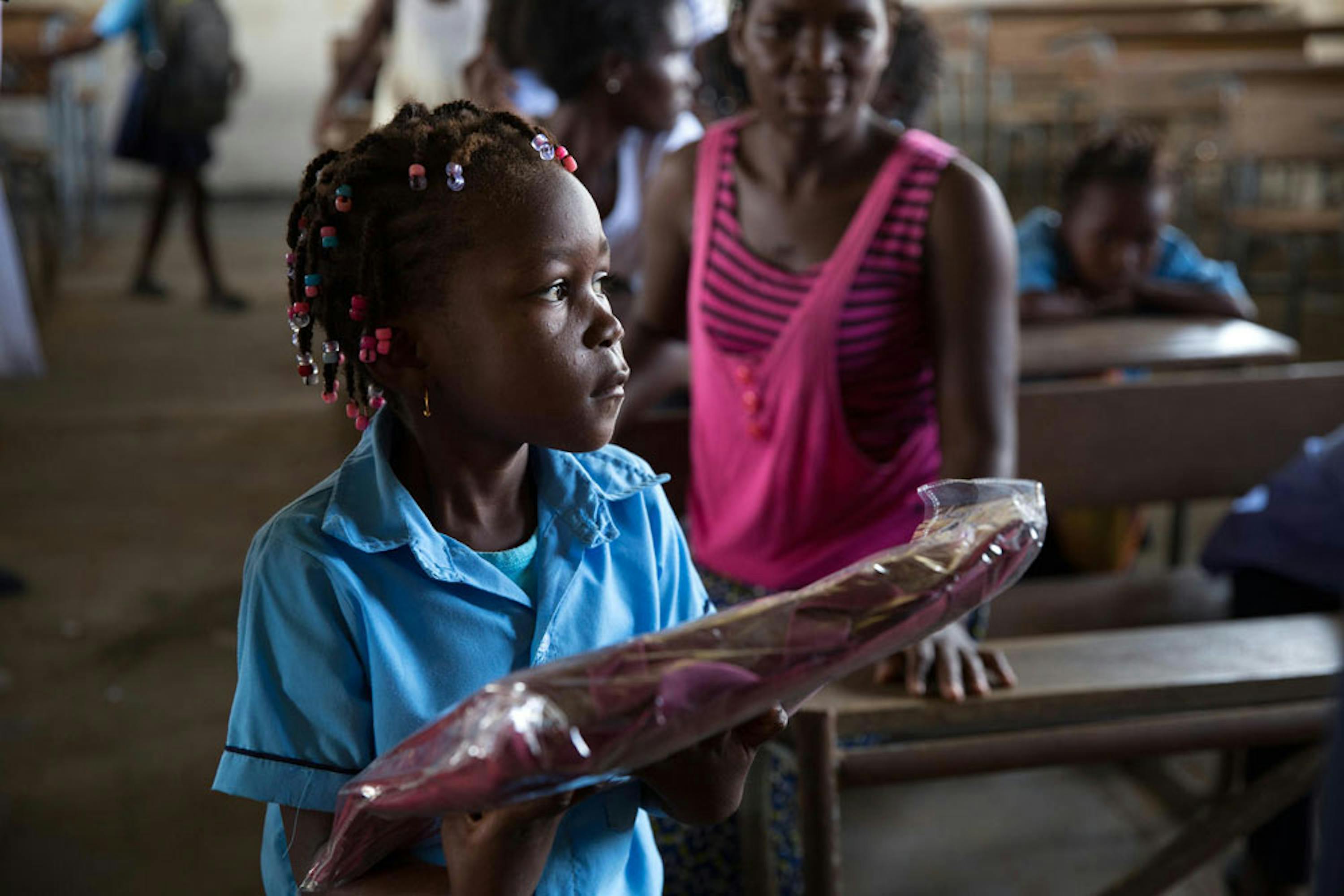 Sonia (6 anni) riceve un kit didattico nella scuola elementare 