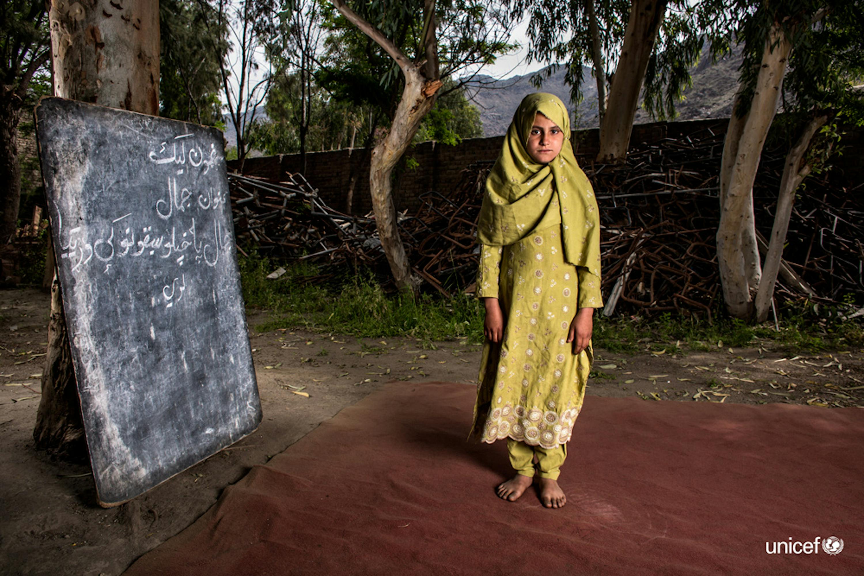 Afghanistan - Assiya, un ragazza di 10 ani, accanto a  i resti della scuola  Bodyalai distrutta durante un'esplosione nel 2015, © UNICEF/UN0309012/Kokic