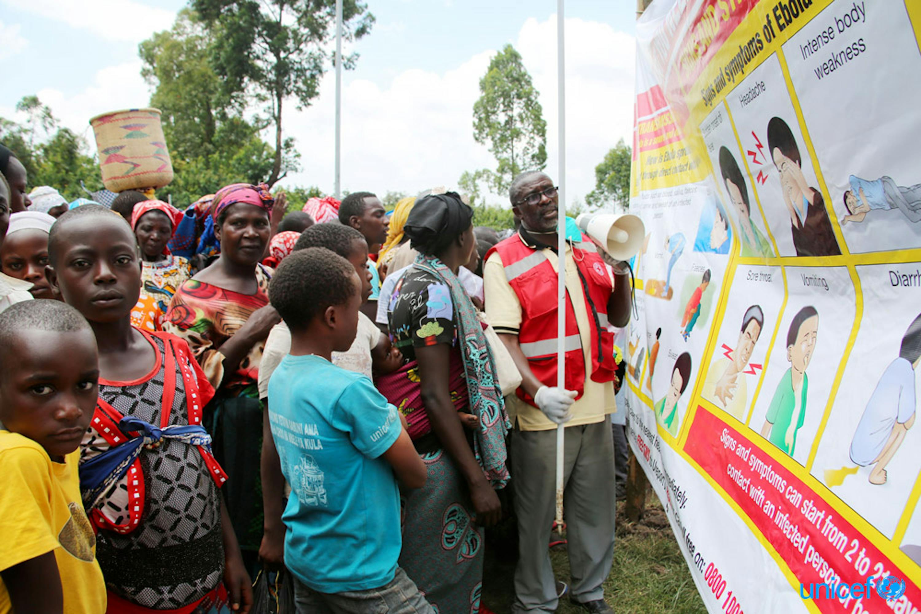 Uganda - un volontario della Croce Rossa insegna alla persone che provengono dalla Repubblica Democratica del Congo sui pericoli dell'ebola usando uno striscione fornito dall'UNICEF  nella città di confine di Bunagana, Uganda-RDC, © UNICEF/UN0307815/Adriko