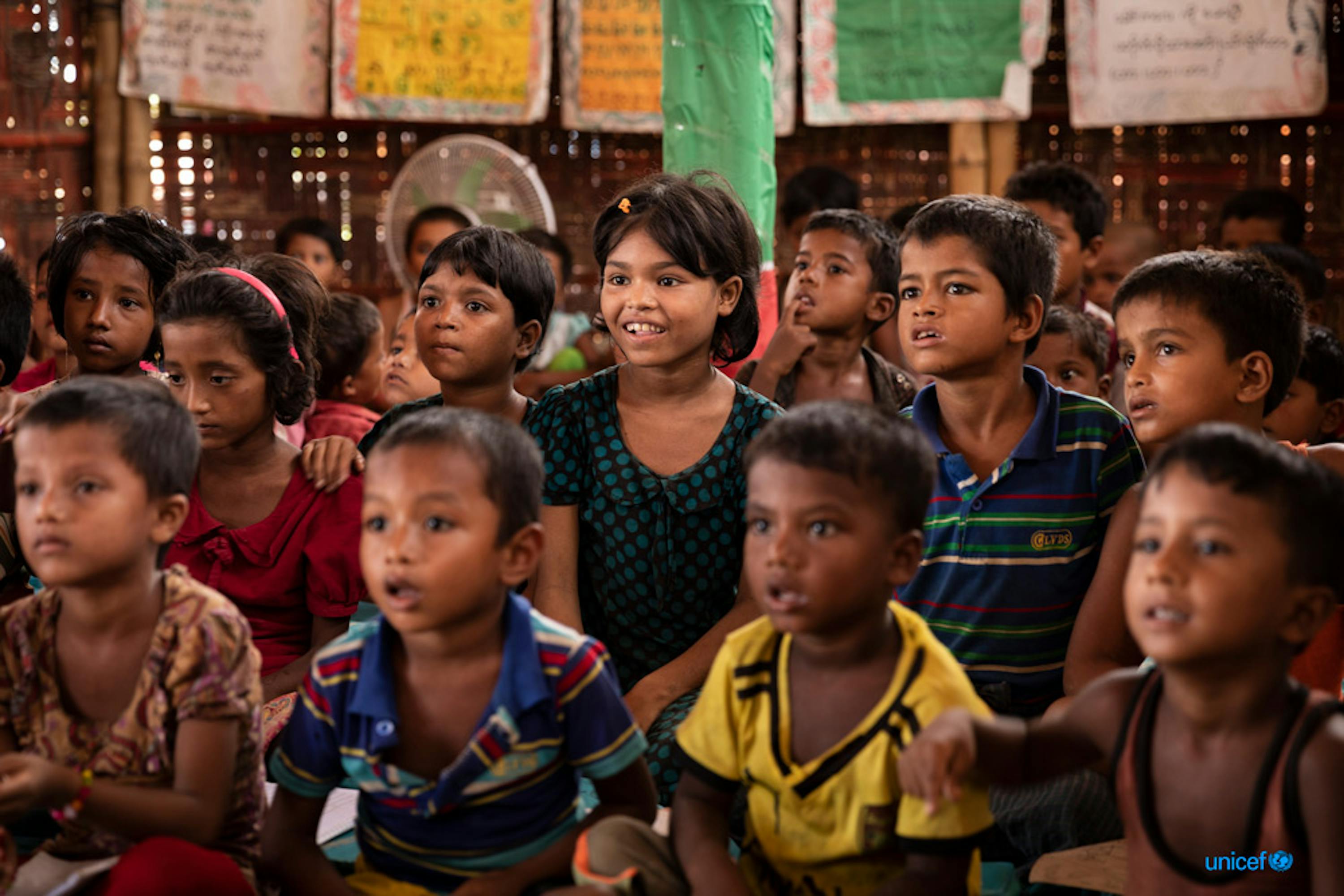 Un gruppo di bambini recitano la lezione quotidiana in uno spazio di apprendimento sostenuto dall'UNICEF nel campo di Kutupalong-Balukhali, Cox's Bazar, Bangladesh © UNICEF/UN0326961/Brown
