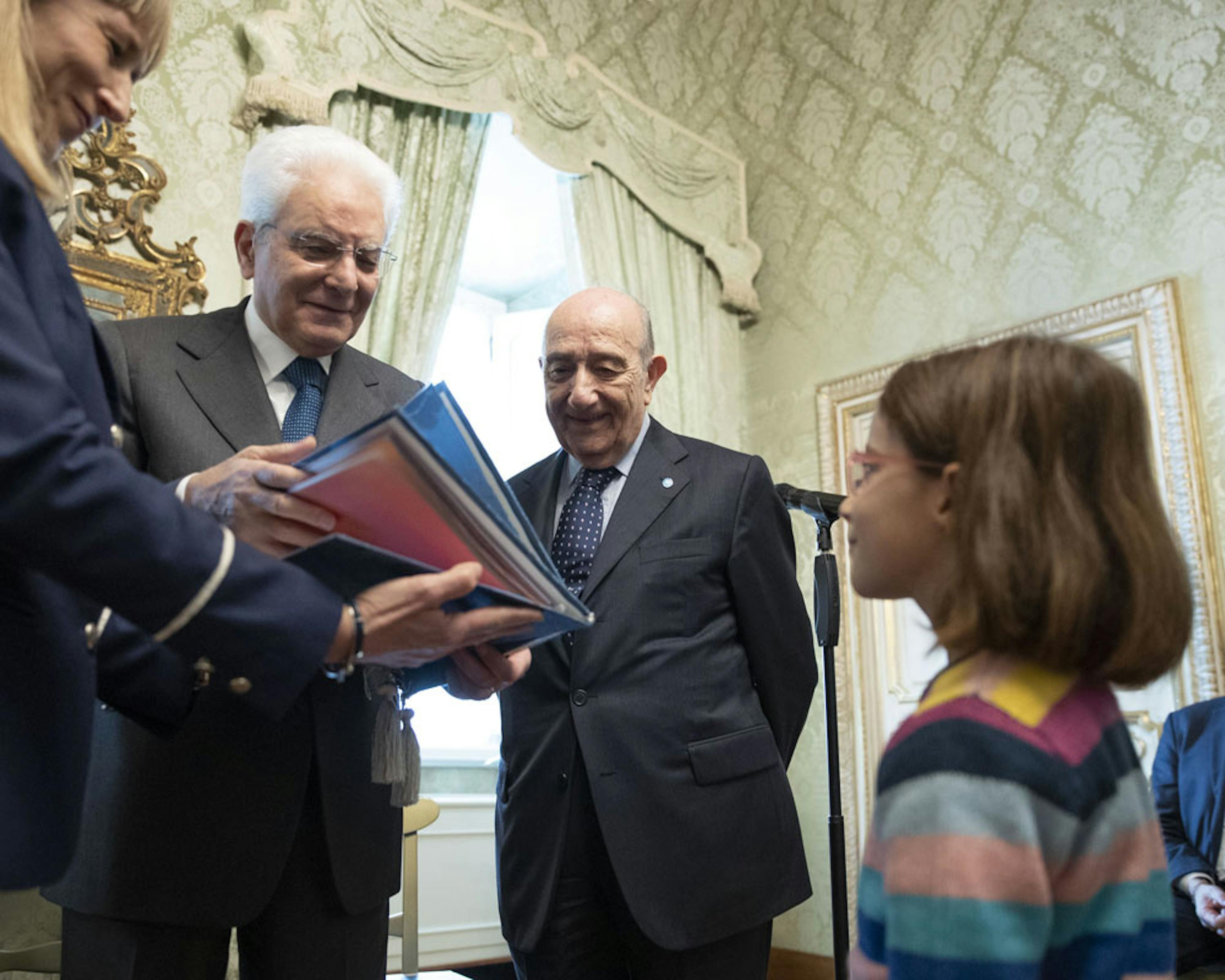 Il presidente Mattarella riceve una copia speciale della Convenzione sui Diritti dell'Infanzia. Accanto a lui il presidente dell'UNICEF Italia Francesco Samengo e la piccola Carolina - ©Quirinale