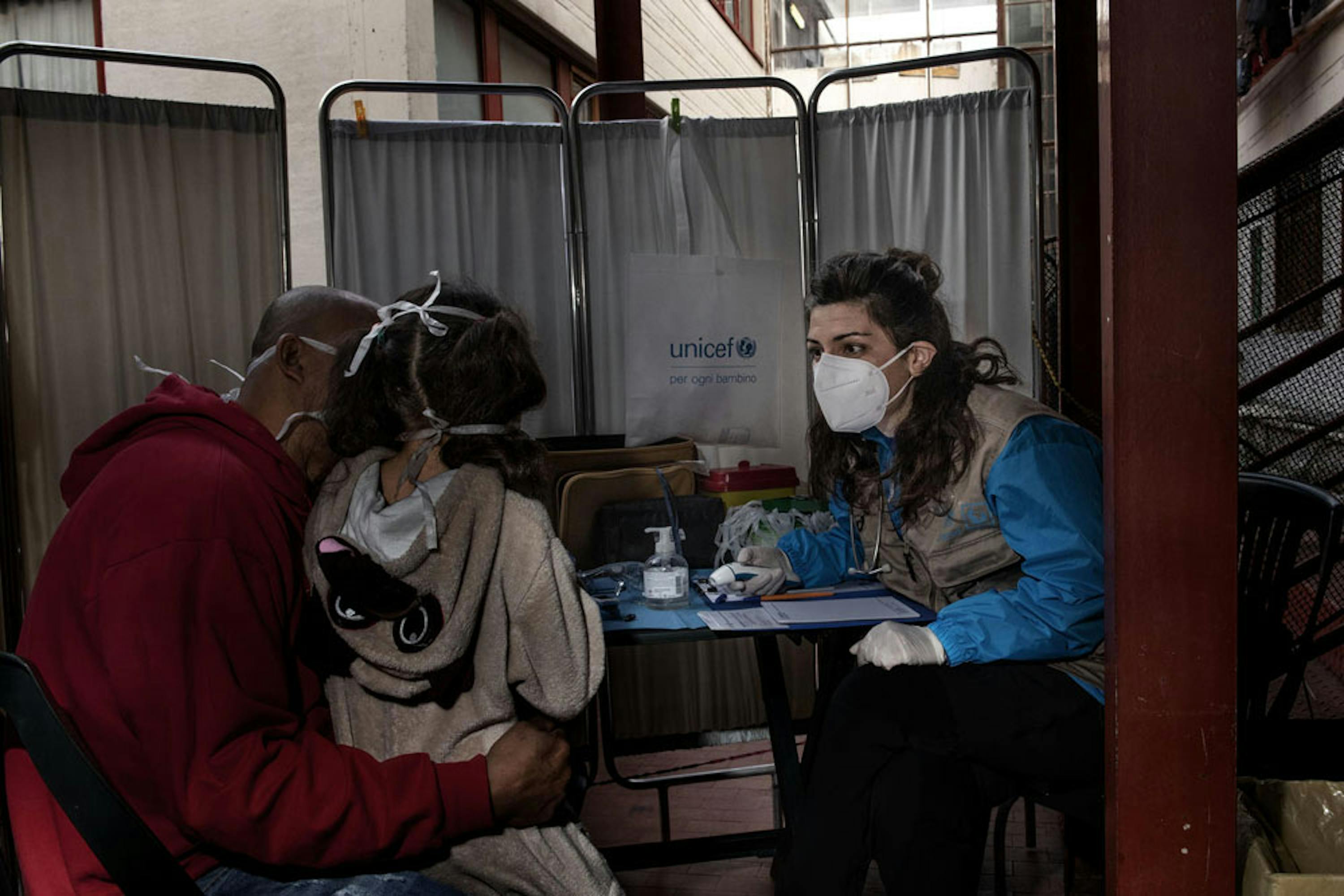 Una dottoressa del team mobile UNCEF-INTERSOS visita padre e figlia, immigrati dal Venezuela, in un edificio occupato a Roma - © UNICEF/UNI319137/Romenzi