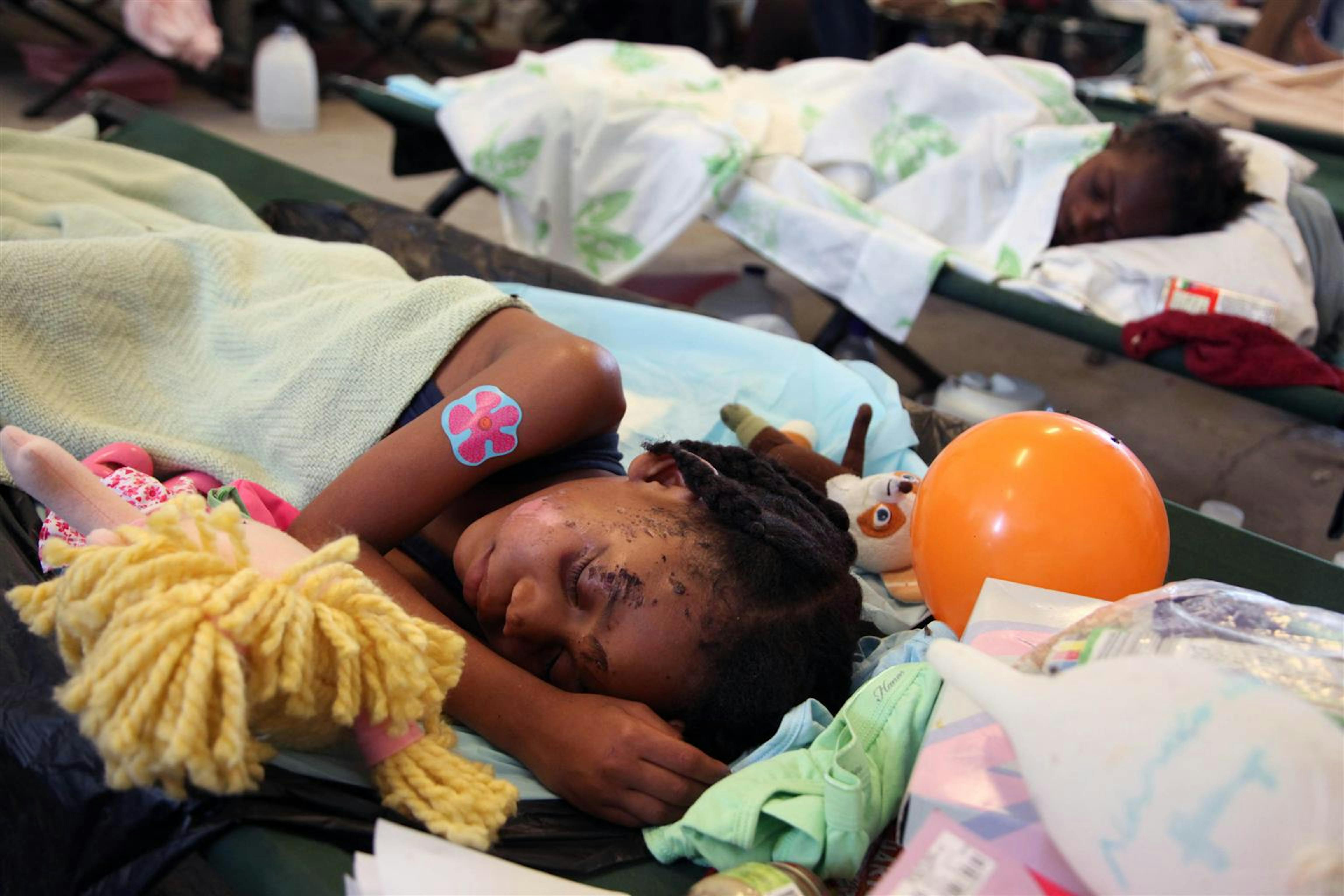 Questa bambina ferita è rimasta isolata dai genitori. Mentre procedono le ricerche è ospite presso un ospedale da campo in attesa di essere inserita in una casa-famiglia di Port-au-Prince  