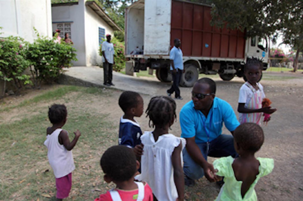 Un operatore dell'UNICEF parla con alcuni bambini dell'orfanotrofio di Tabarre, quartiere della capitale Port-au-Prince