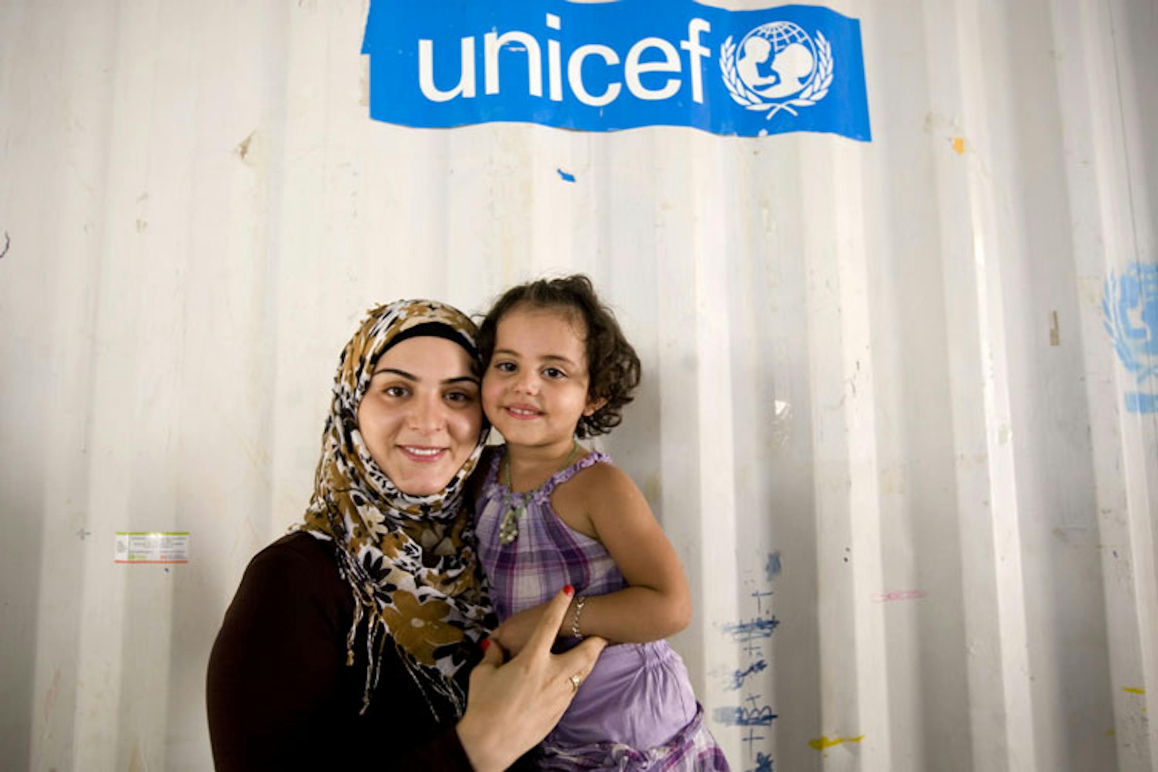 Marwa El Hab con una bambina nello spazio giochi protetto allestito dall'UNICEF nel Campo profughi di Nahr El Bared. ©Ada Lombardi/UNICEF Italia/2010