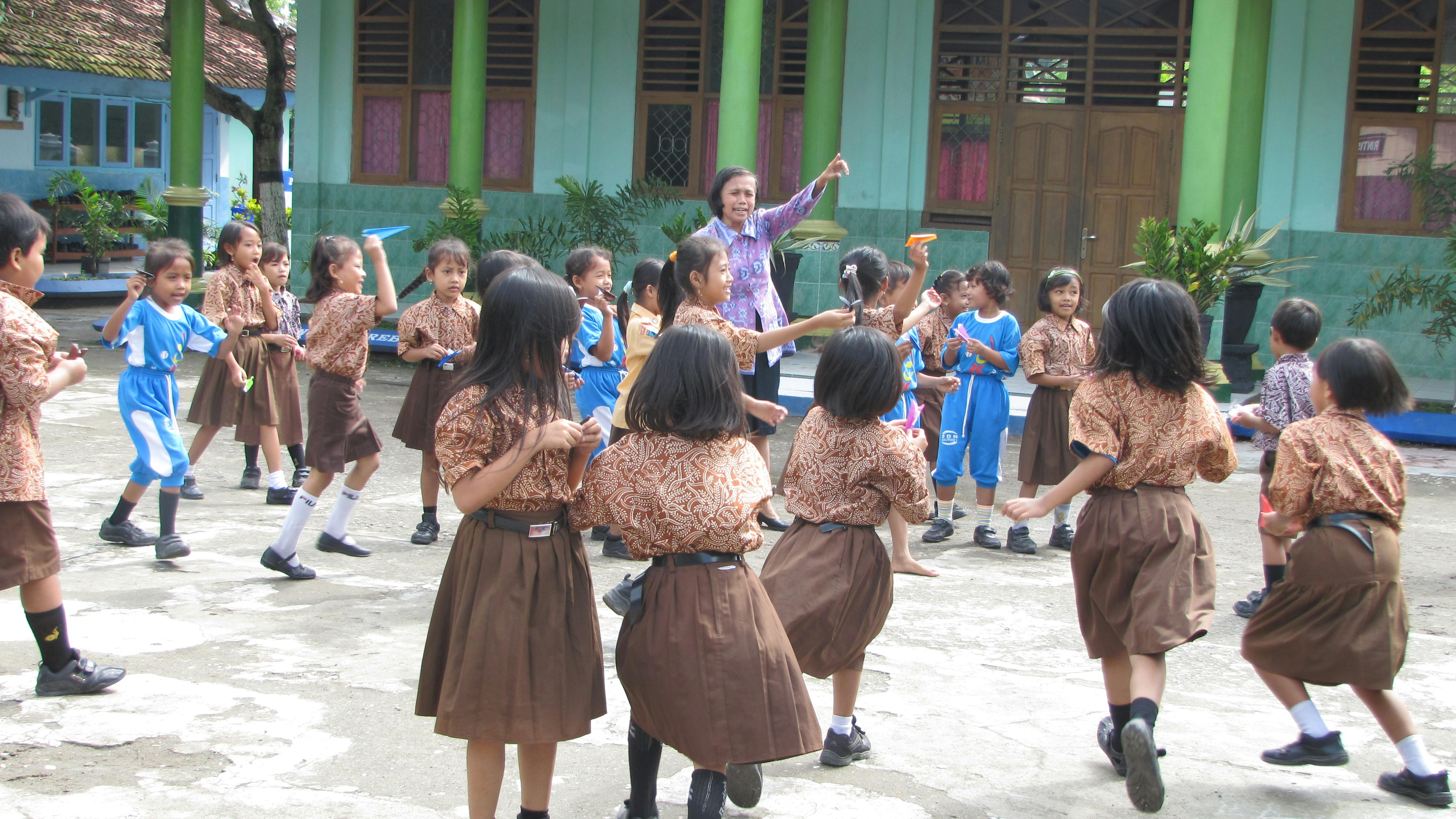 Studenti indonesiani fanno valore gli aeroplanini di carta nel cortile della loro scuola. ©Alessandra Ficarra
