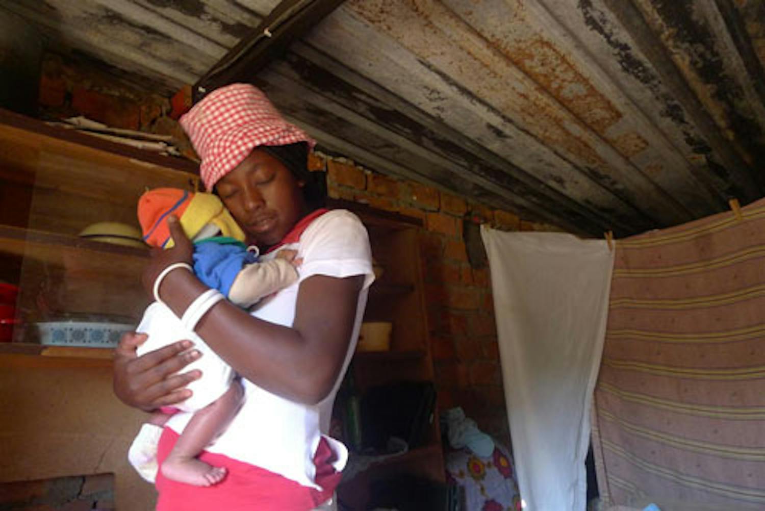 Questa mamma coccola il suo bambino nella loro casa alla periferia di Lusaka (Zambia). Ha scoperto di essere sieropositiva mentre era incinta, e ora partecipa al programma di prevenzione della trasmissione madre-figlio dell’HIV. 