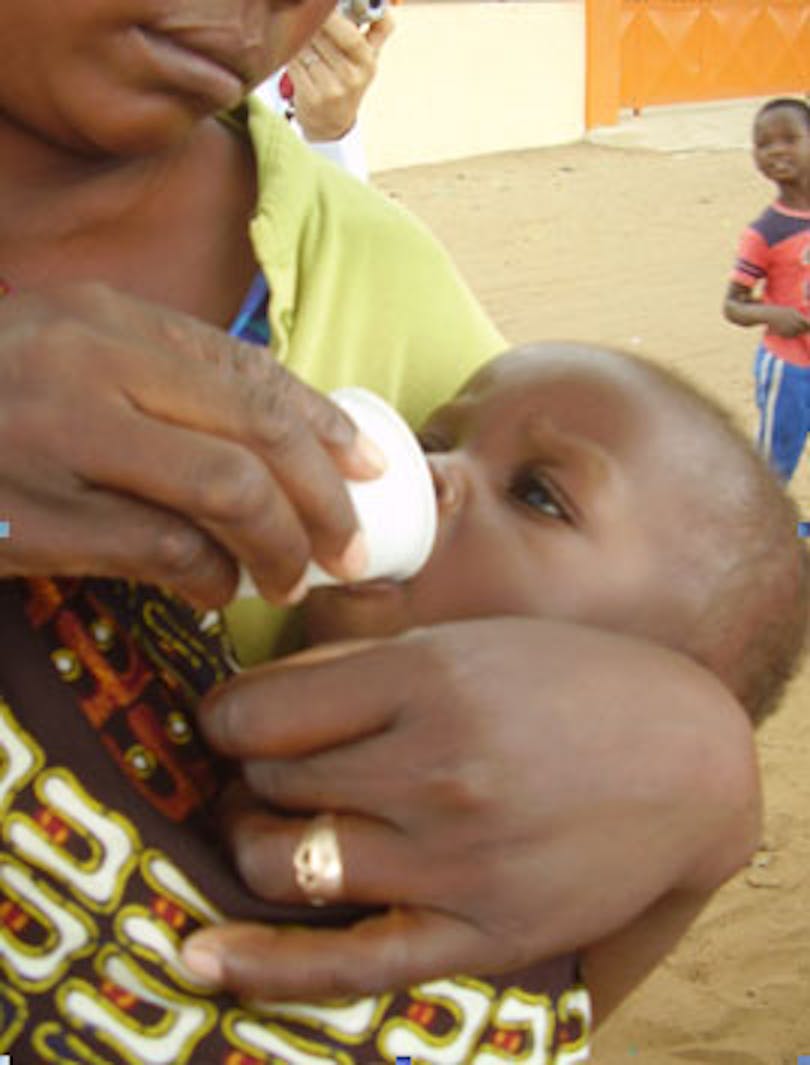 Una mamma aiuta a dare Albendazol (anti parassitaro) sciolto nell’acqua al suo bambino. ©Manuela Cau