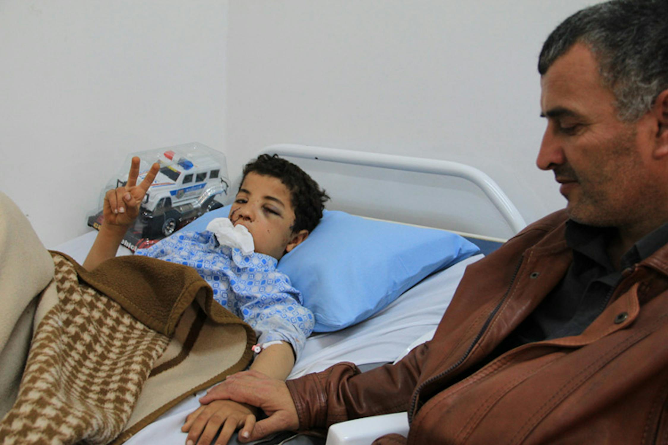 Mufteh, il bambino protagonista di questa storia, in ospedale a Bengasi prima dell'operazione. Accanto a lui è il padre, Mohamed - ©UNICEF Libia/2011/J.Elder