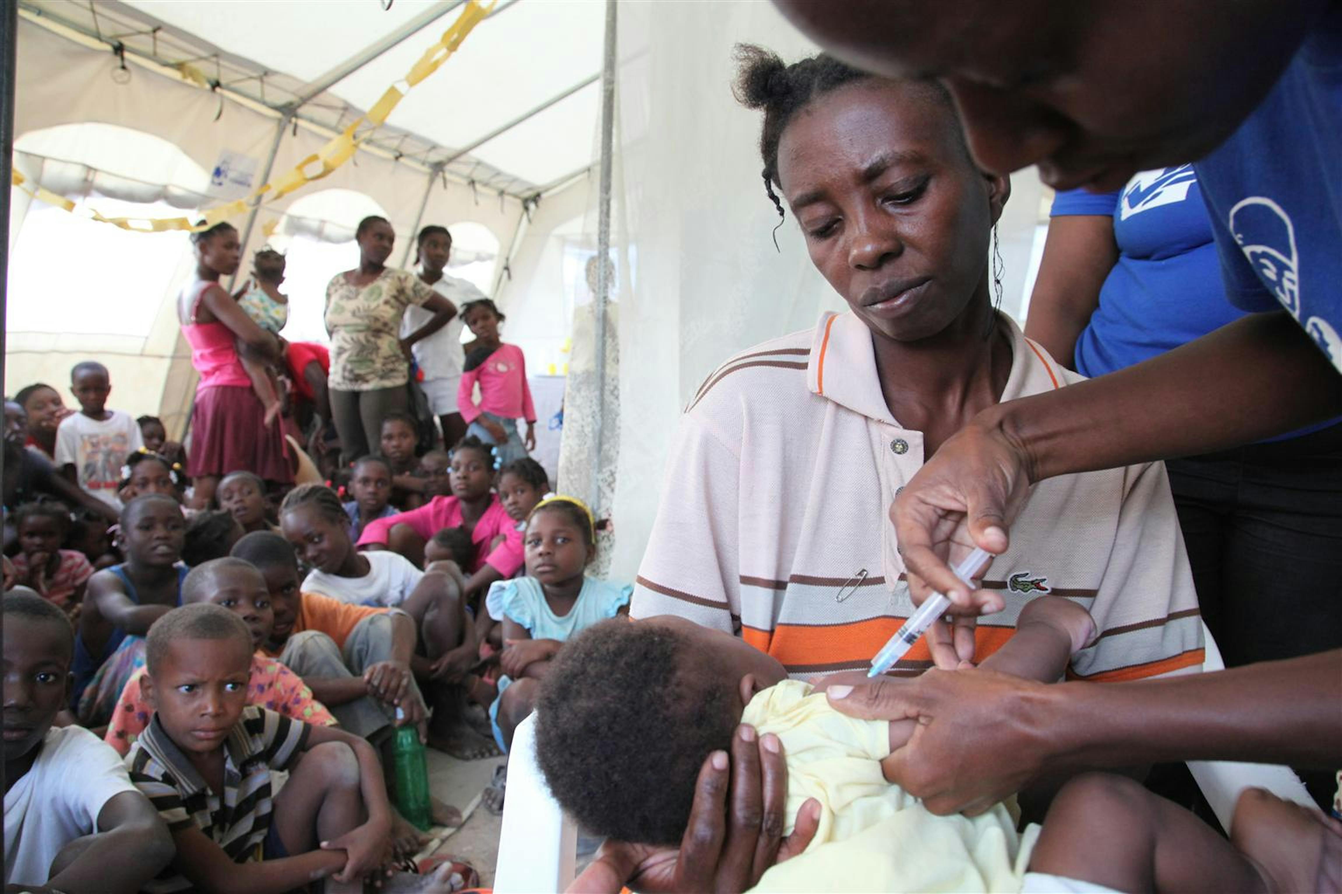 Haiti. Un bambino in braccio alla sua mamma viene vaccinato in una clinica mobile allestita dopo il terremoto©UNICEF/NYHQ2010/LeMoyne