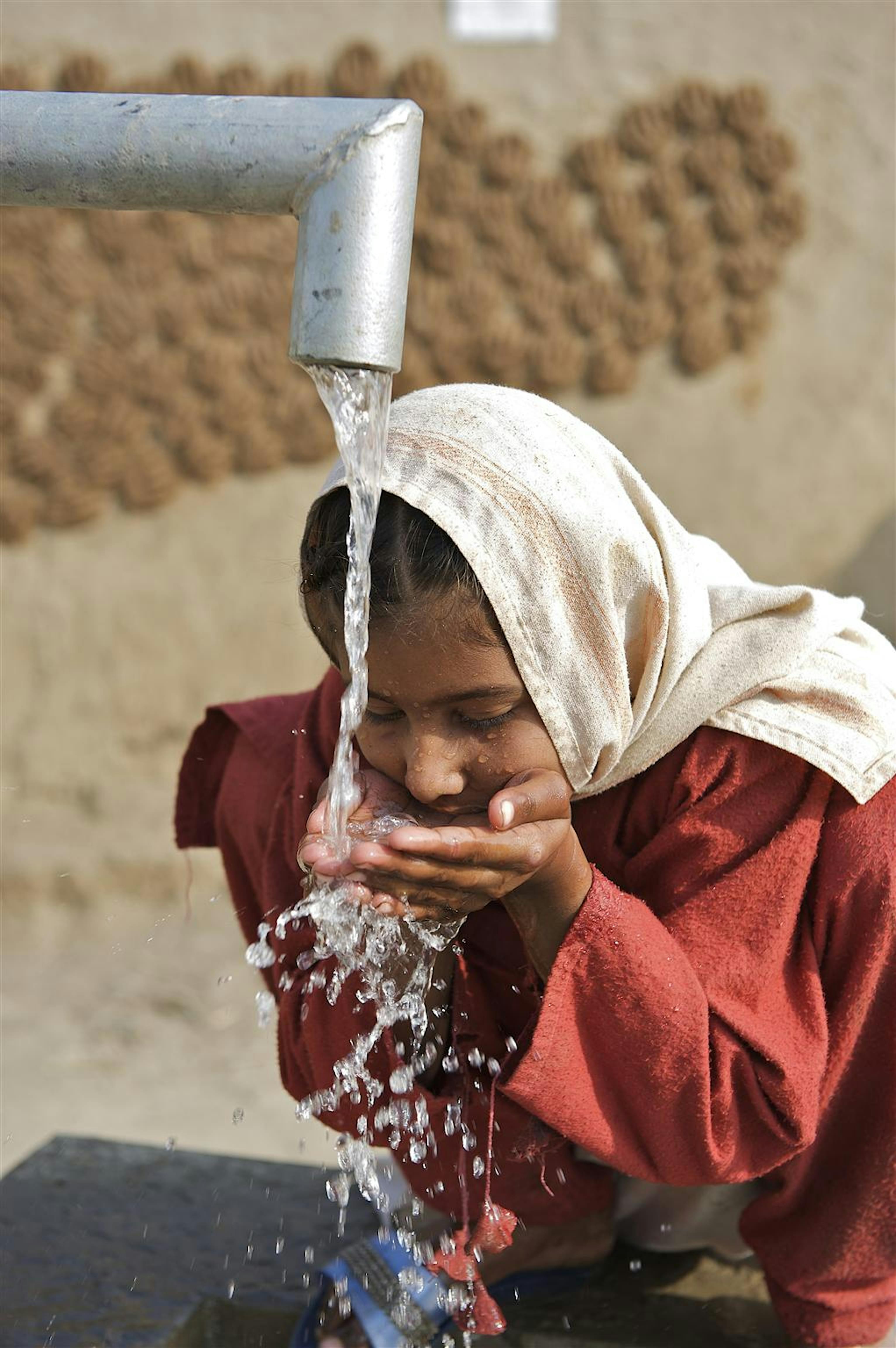 Una bambina si disseta a una fontanella installata dall'UNICEF in un villaggio del distretto di Muzaffargarh, in Pakistan - ©UNICEF/NYHQ2011-0082/S.Noorani