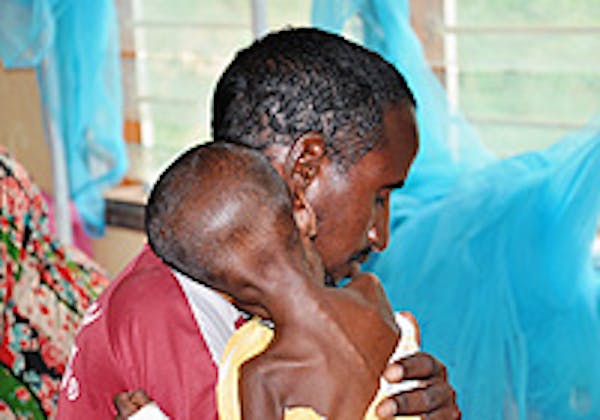 Il piccolo Aden in braccio al suo papà all'ospedale di Hagadera, nel campo profughi di Dadaab. ©UNICEF/Kenya/2011/Tidey