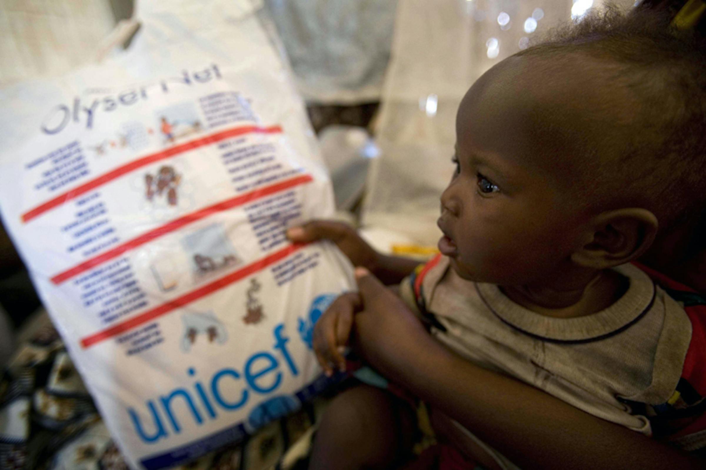 Réponse (7 mesi) con sua madre Nyanxima riceve una zanzariera nel campo per sfollati di Kibati, provincia di Nord Kivu (Rep. Democratica del Congo) - ©UNICEF/NYHQ2008-1232/Holt