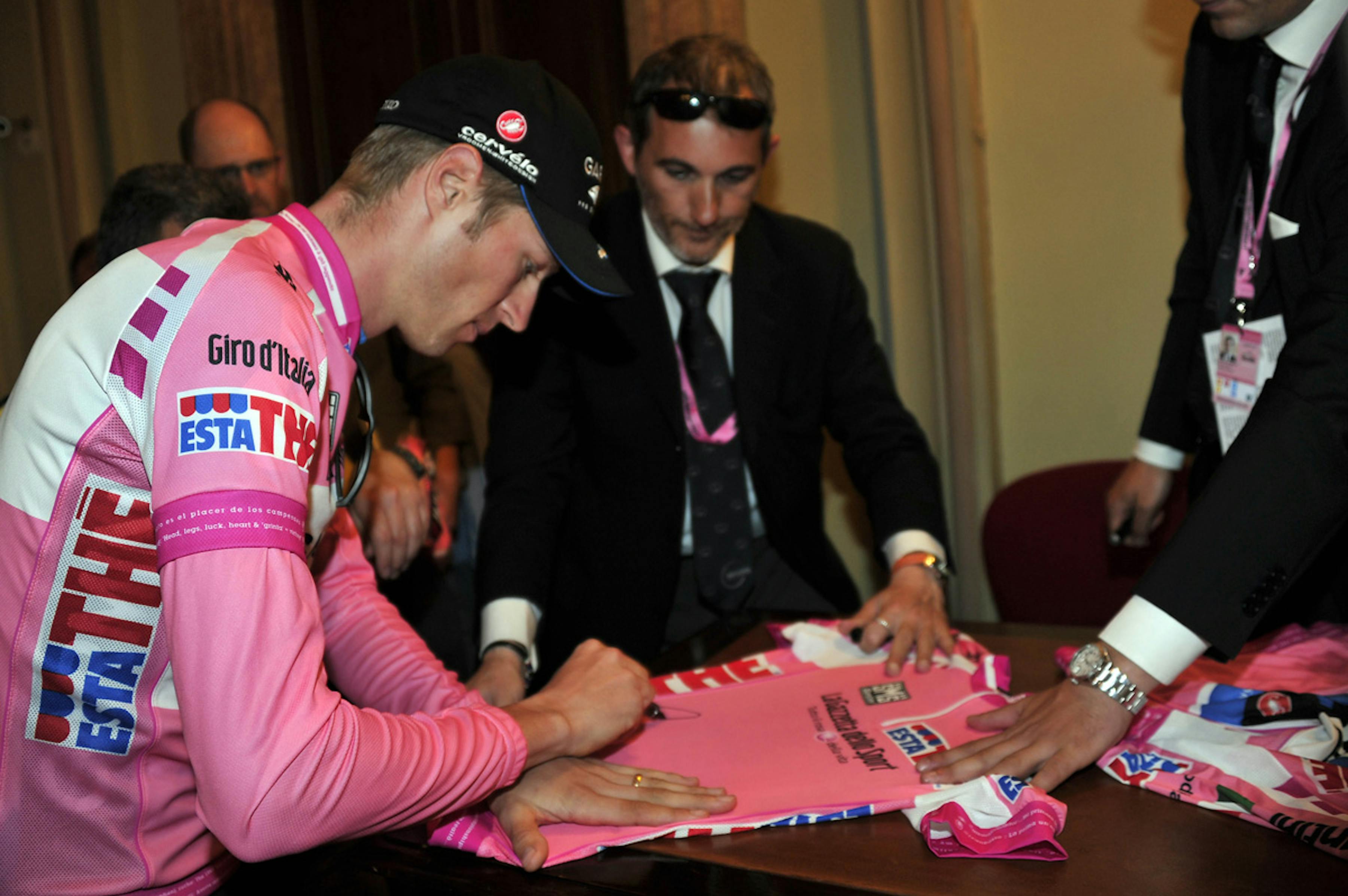 Il vincitore del Giro d'Italia 2012, il canadese Ryder Hejsedal, autografa la maglia rosa per l'UNICEF - ©Giro d'Italia/2012