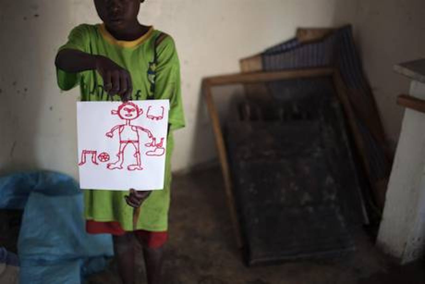 Un bambino ospite del centro dell'UNICEF mostra orgoglioso il suo disegno