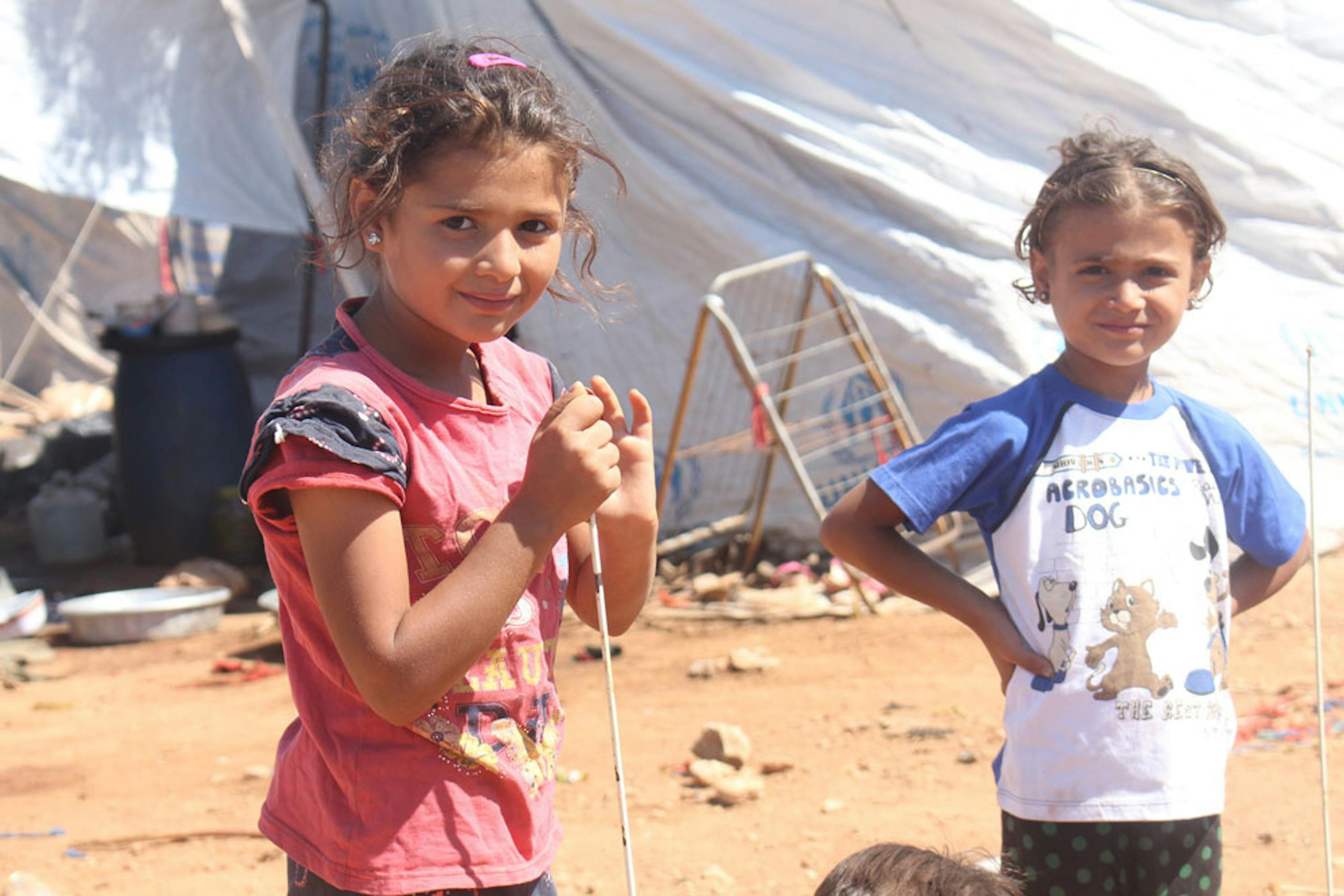 Shahed (5 anni) e una sua amica vivono in uno degli accampamenti sorti lungo la strada in un sobborgo di Aleppo ovest, in Siria - ©UNICEF/UN032203/Ourfali