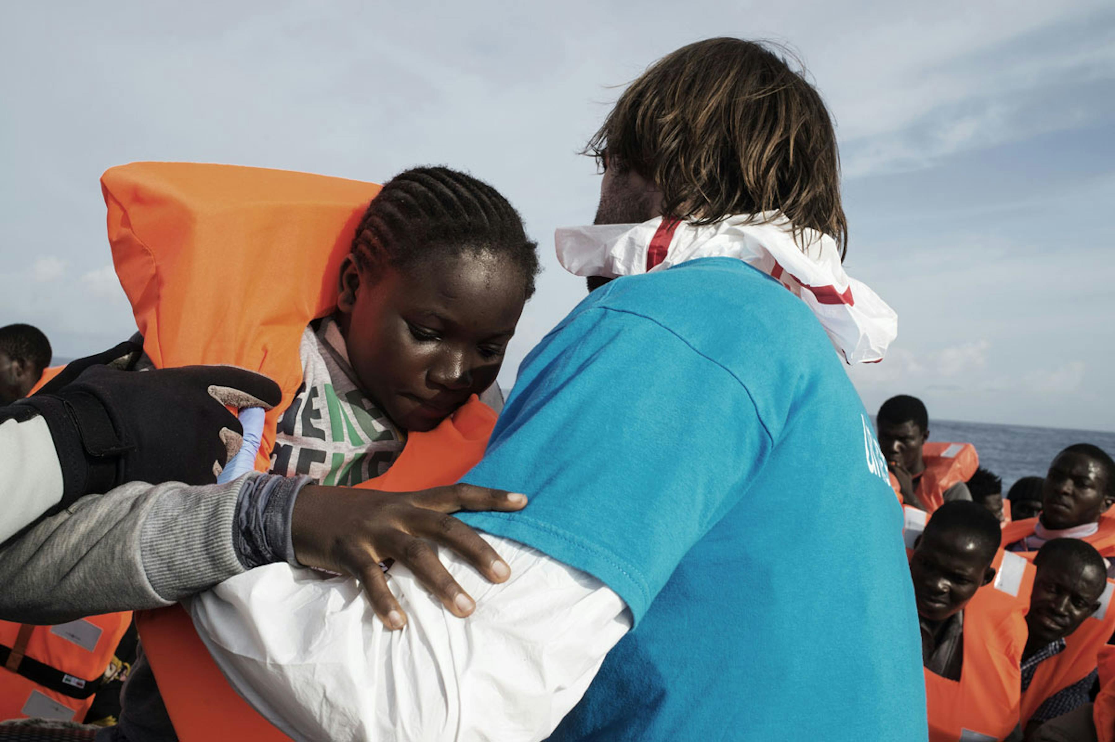 Mar Mediteraneo, 2016. Un volontario italiano aiutare i migranti a trasferirsi dal gommone alla nave Fasan della Marina Militare Italiana