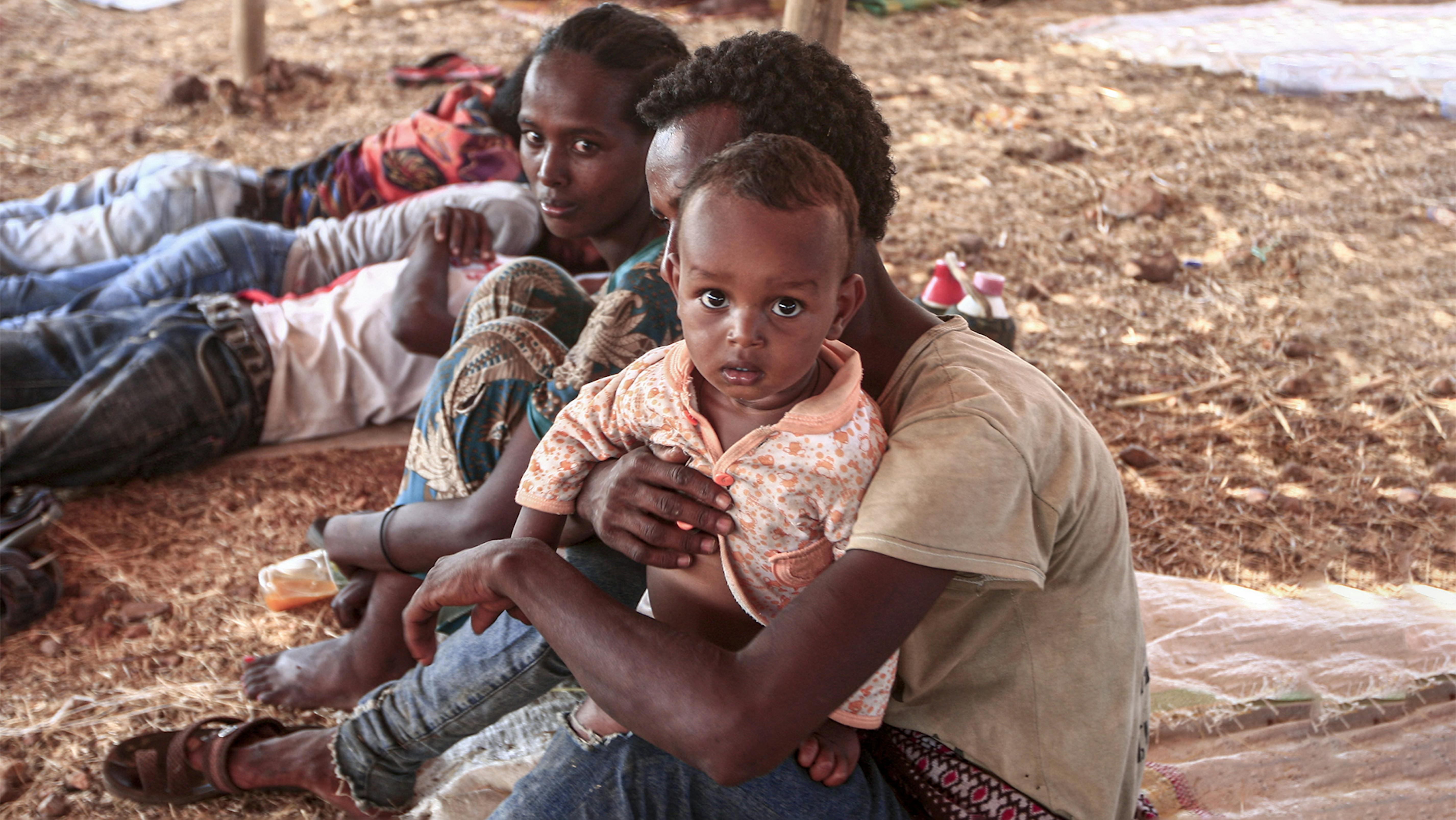 Un bambino rifugiato etiope in braccio a suo papà  © UNICEF/UN0371488/Hamid/AFP Non utilizzabile da media e partner