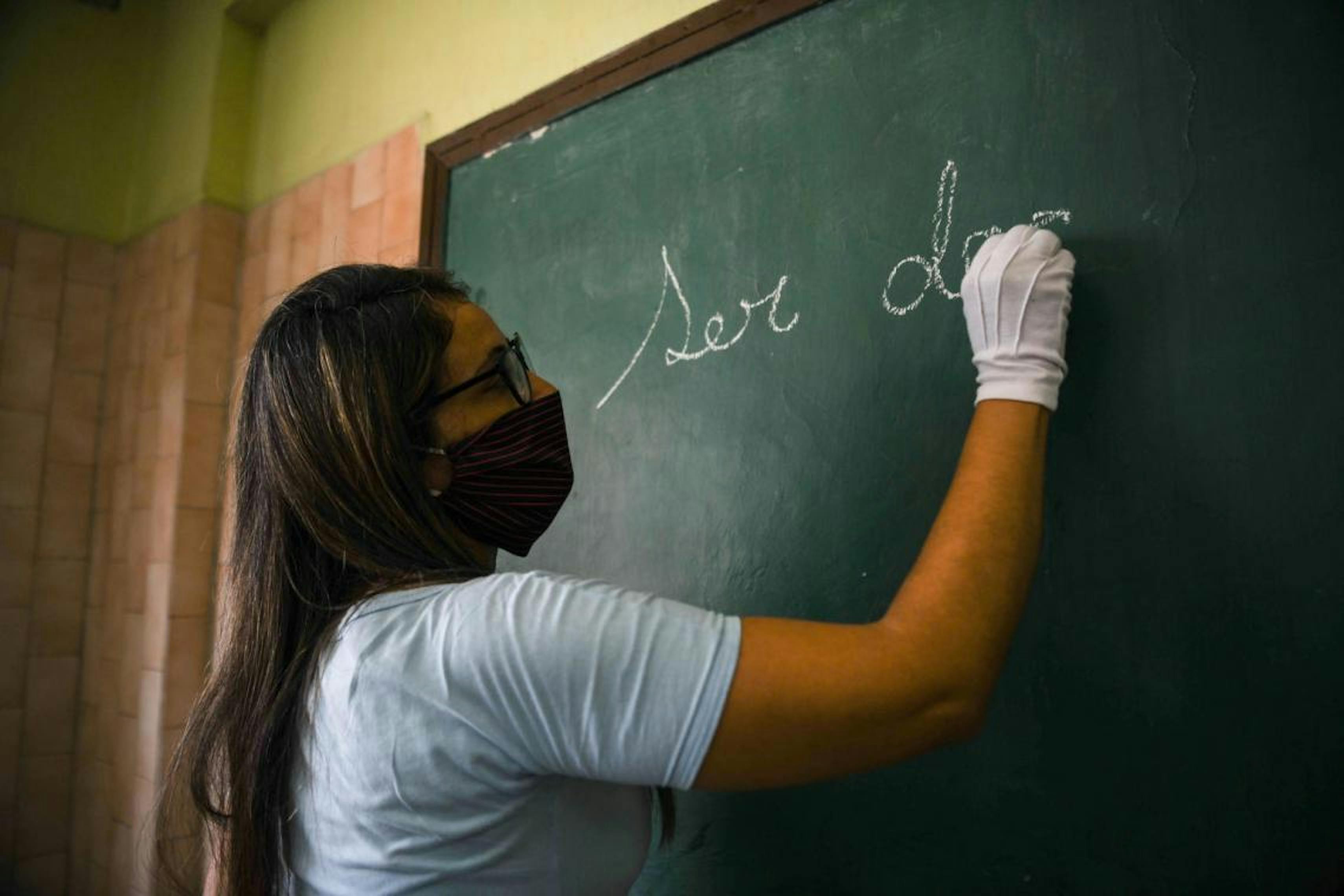 Venezuela, un'insegnante scrive sulla lavagna