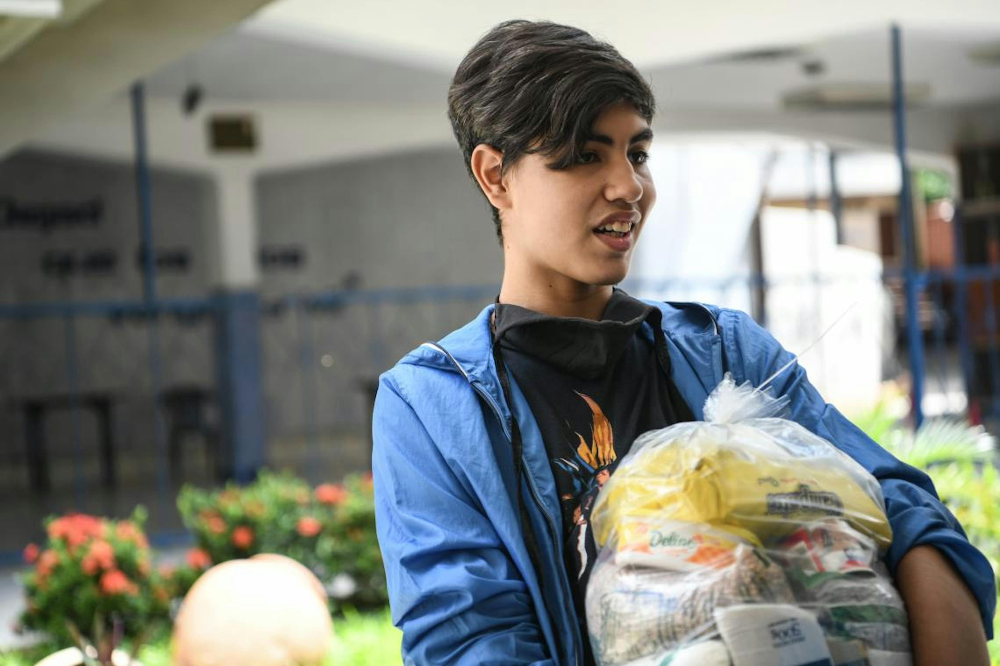 Fernando, 17 anni, riceve un pacco alimentare a scuola, alla periferia di Caracas.