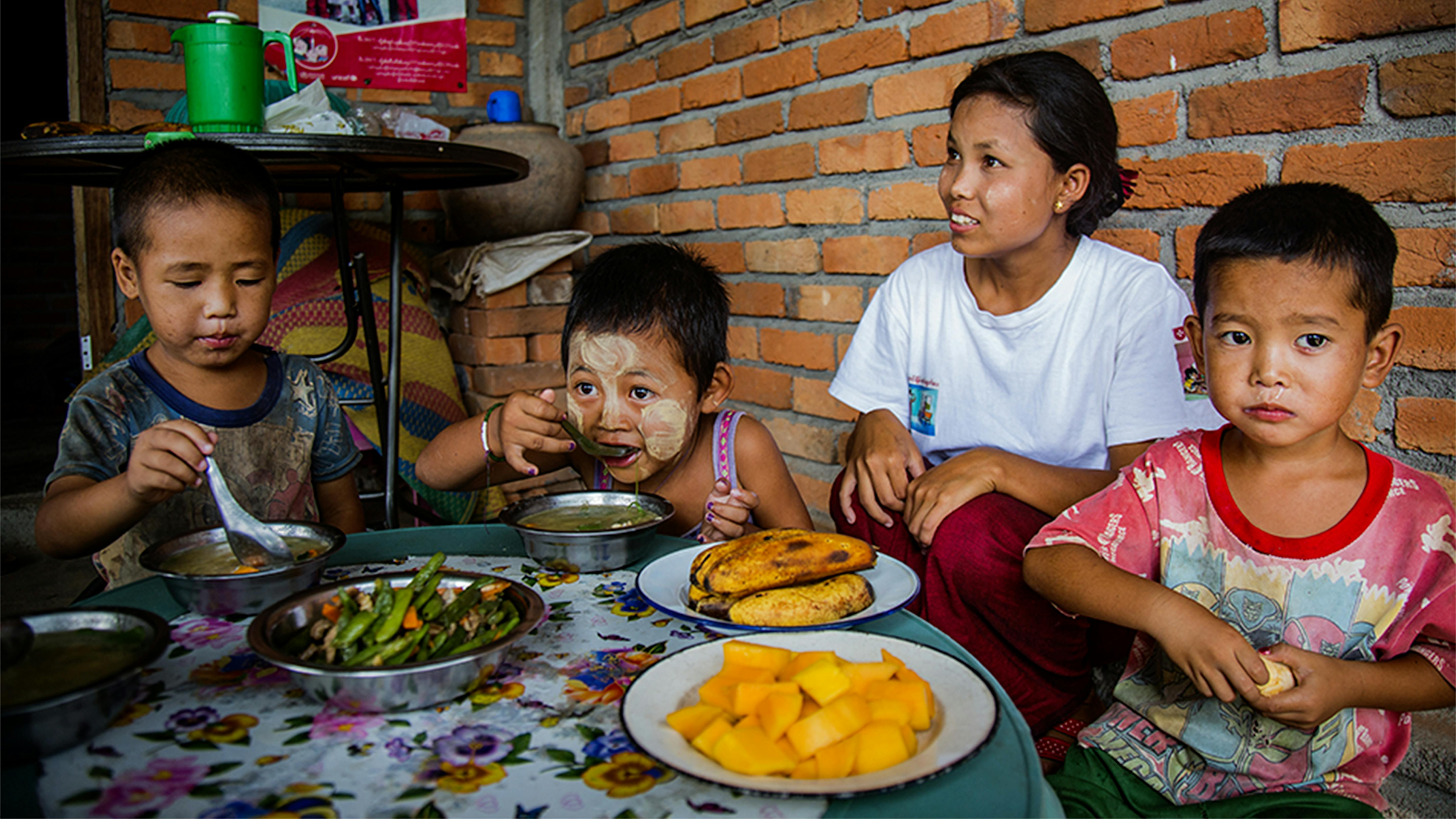 Alcuni bambini si nutrono con del cibo cucinato da operatori sanitari volontari 