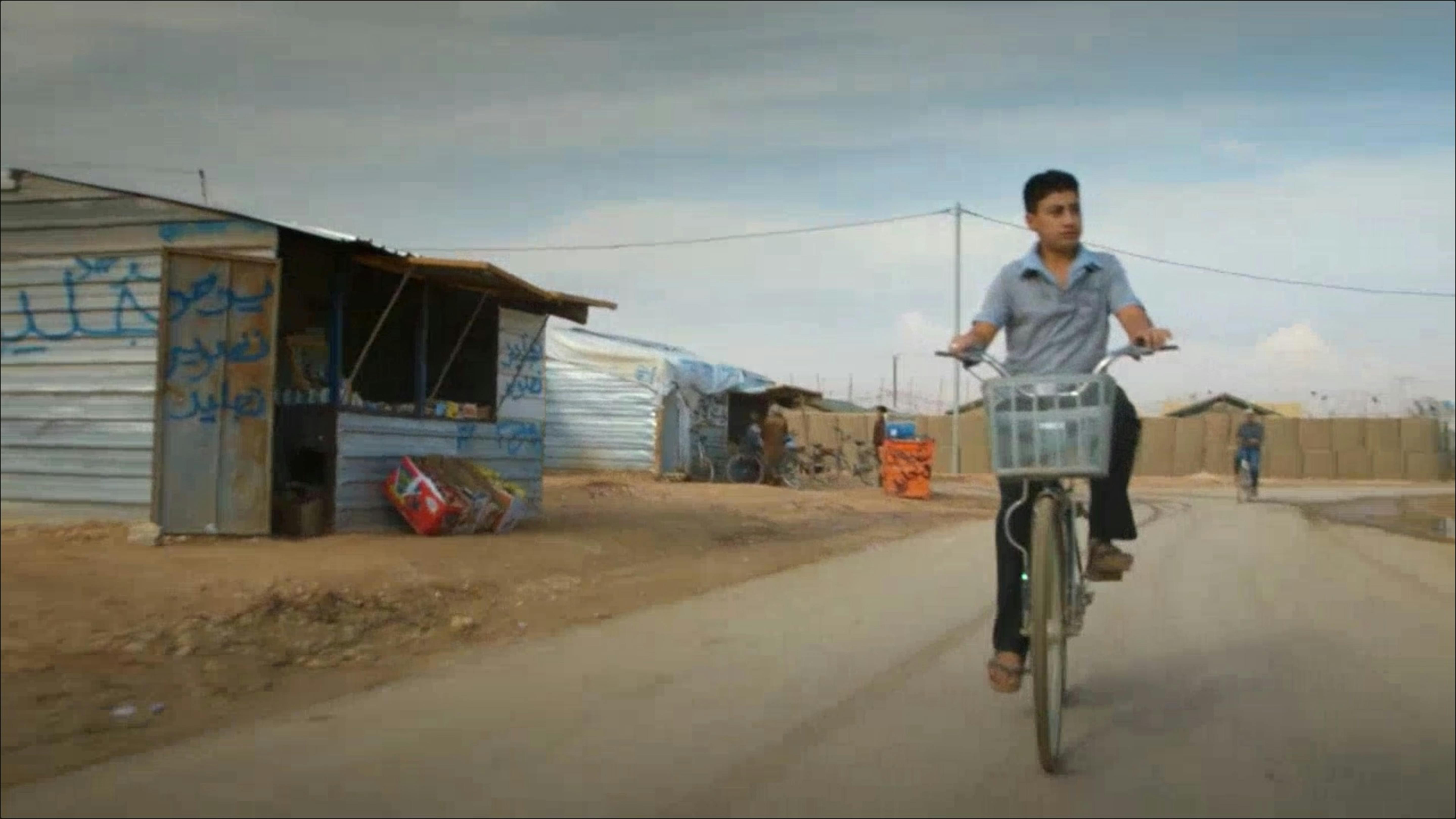 Ahmad, rifugiato siriano, in bici nel campo di Za'arari