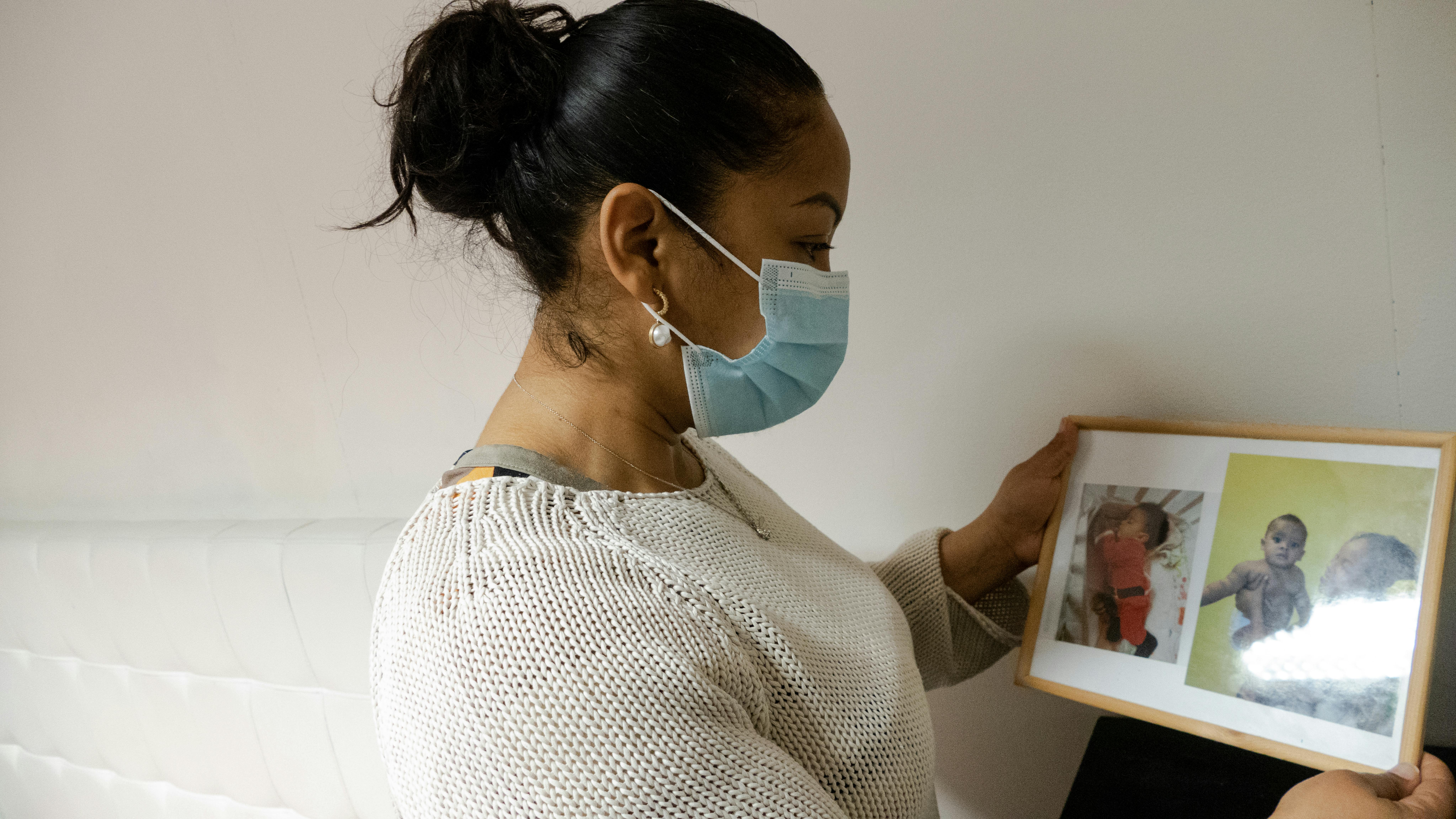 Josy, che vive in una casa occupata, mostra le foto di famiglia agli operatori UNICEF-Intersos