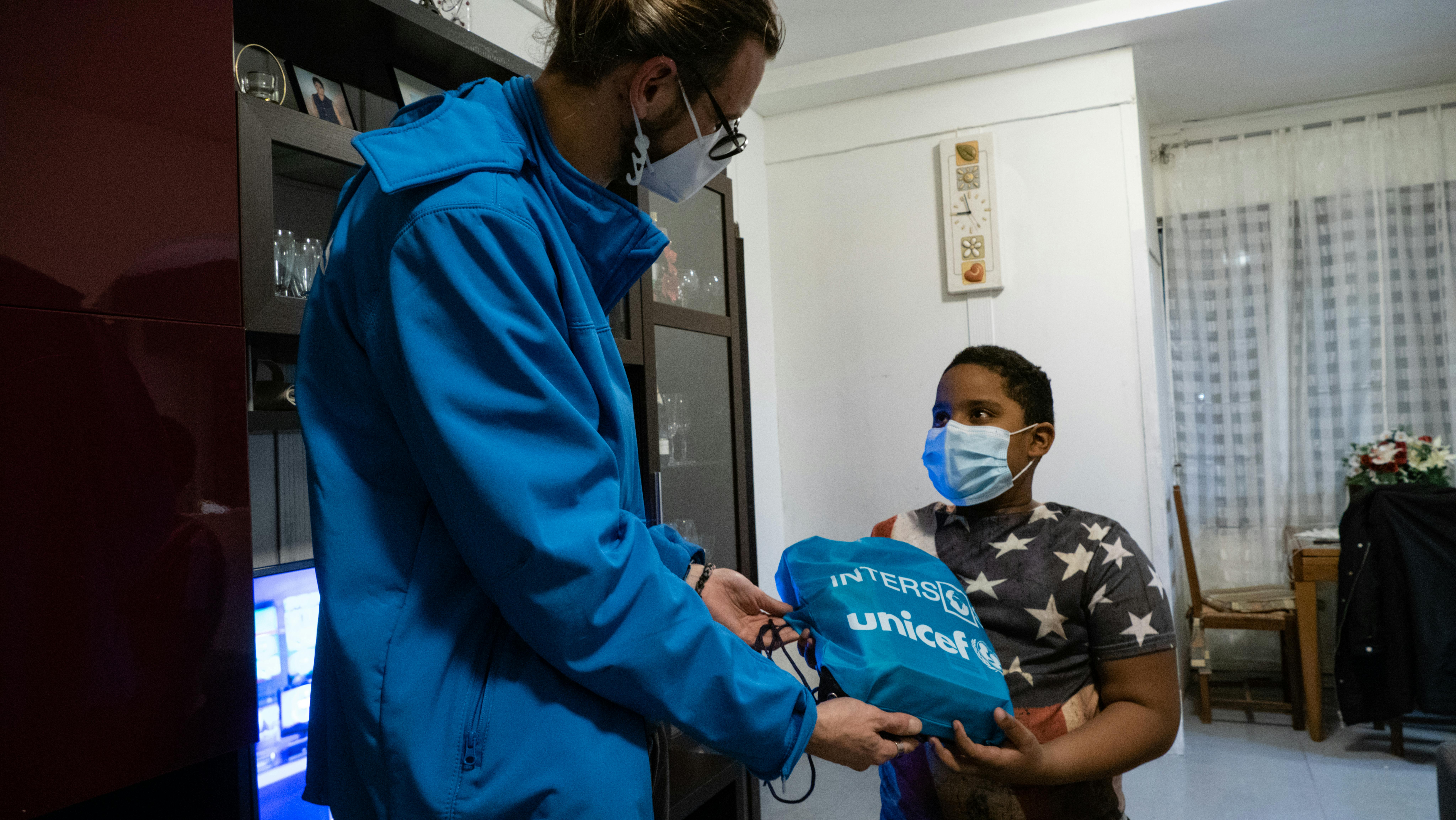 Daniel, il secondo genito, riceve il sacchetto con materiali preparati da UNICEF-Intersos