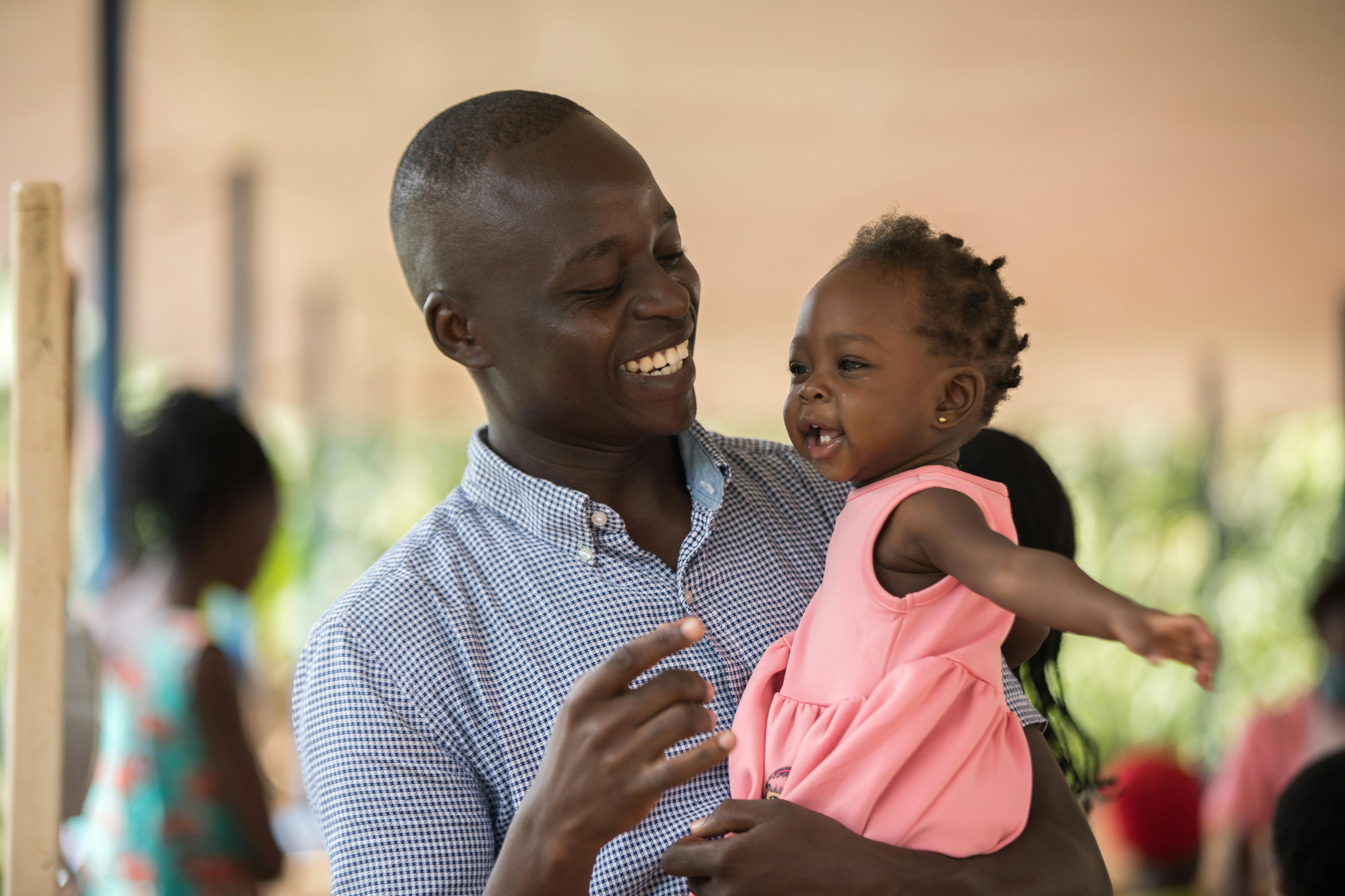 Uganda, papà e figlia in un centro di vaccinazioni UNICEF