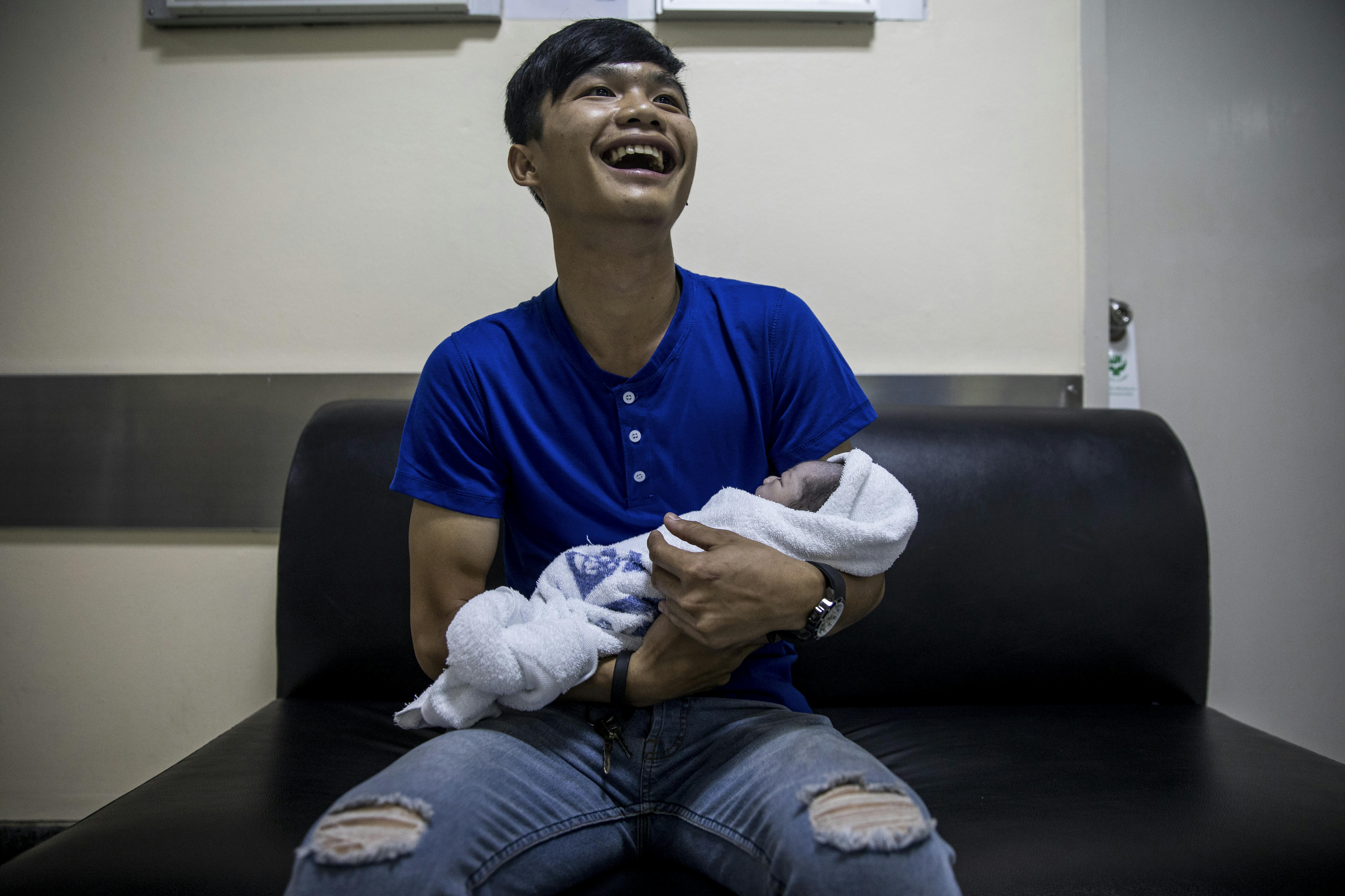 Bangkok, Supidej Jaithon, 20 anni, piange di felicità non appena prende in braccio il suo piccolo neonato, Matt