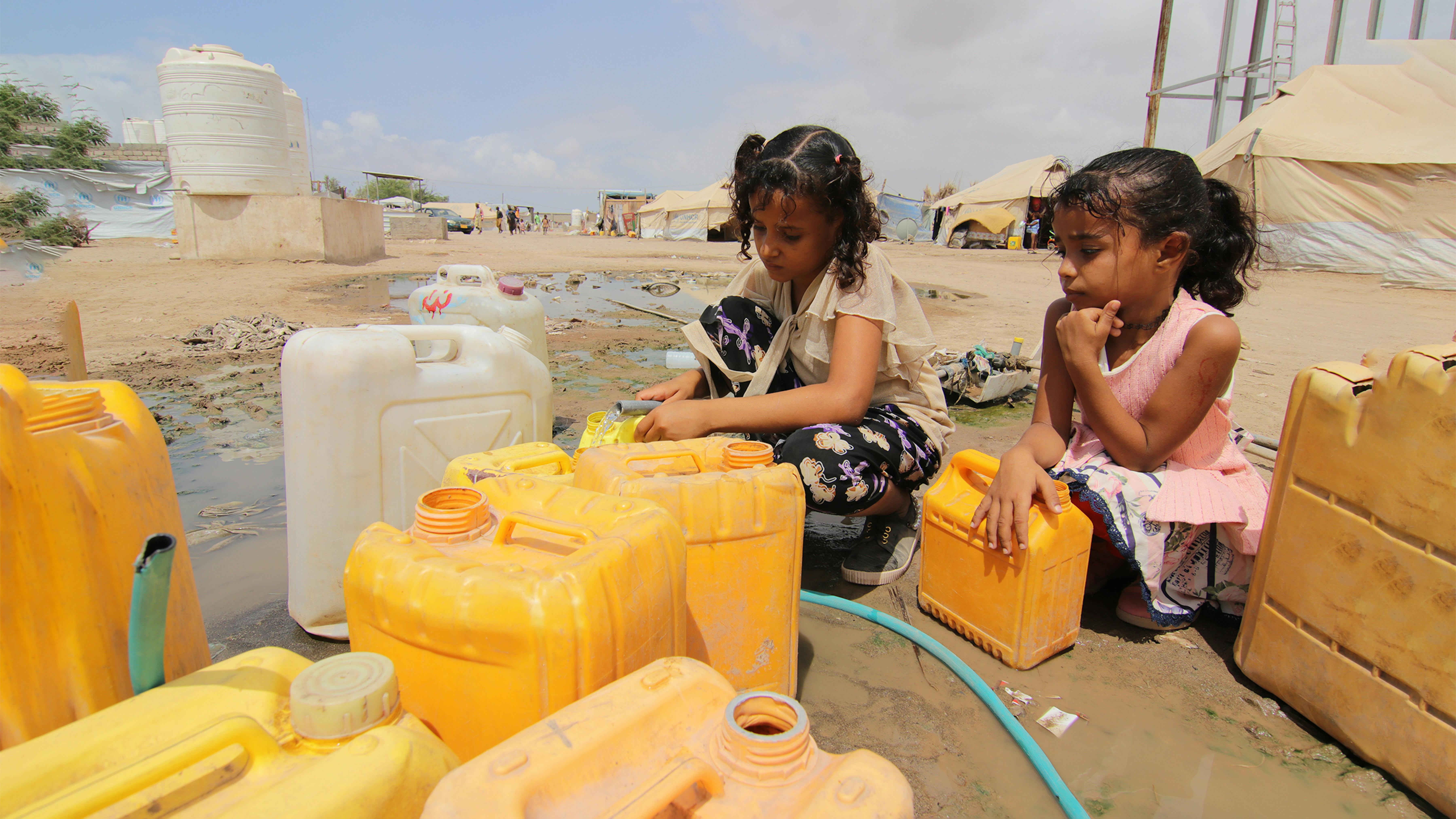 Yemen, due bambine riempiono le taniche di acqua pulita