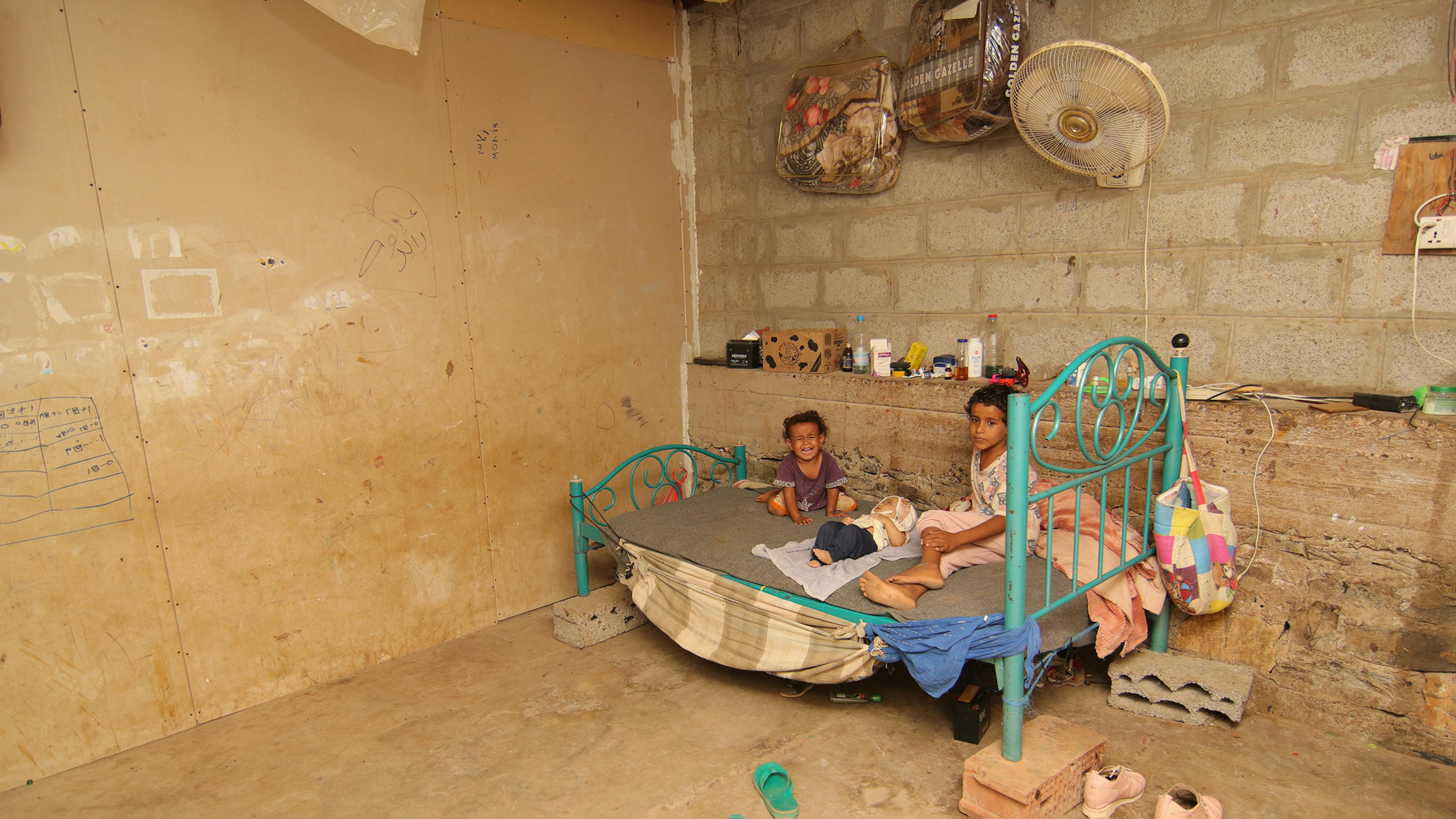 2019, Yemen. Muna con i suoi due fratelli dormono su un unico letto, nel rifugio informale in cui si trovano con tutta la famiglia. 