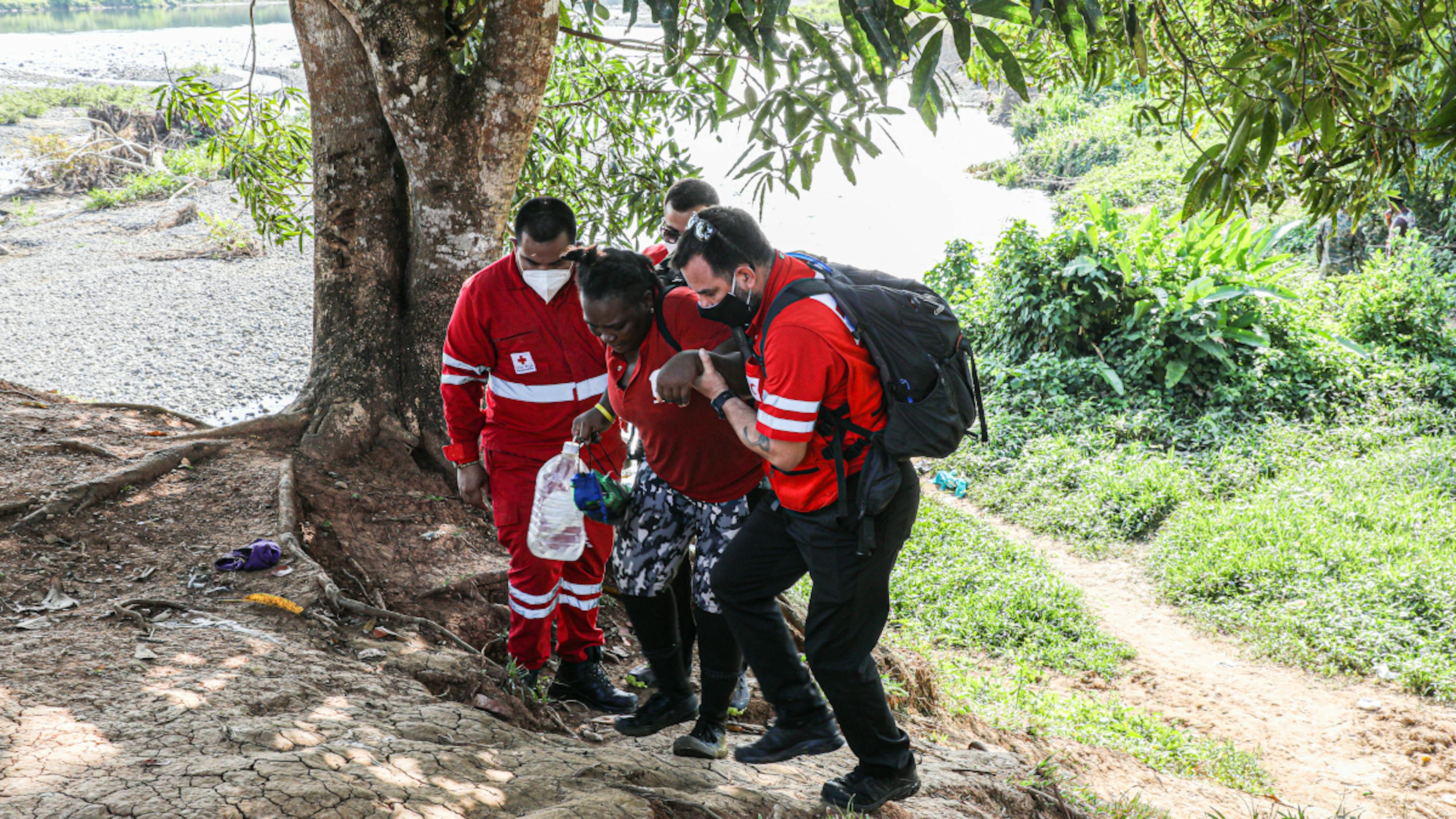 Panama, operatori della croce rossa panamense aiutano una migrante esausta al termine del lungo viaggio