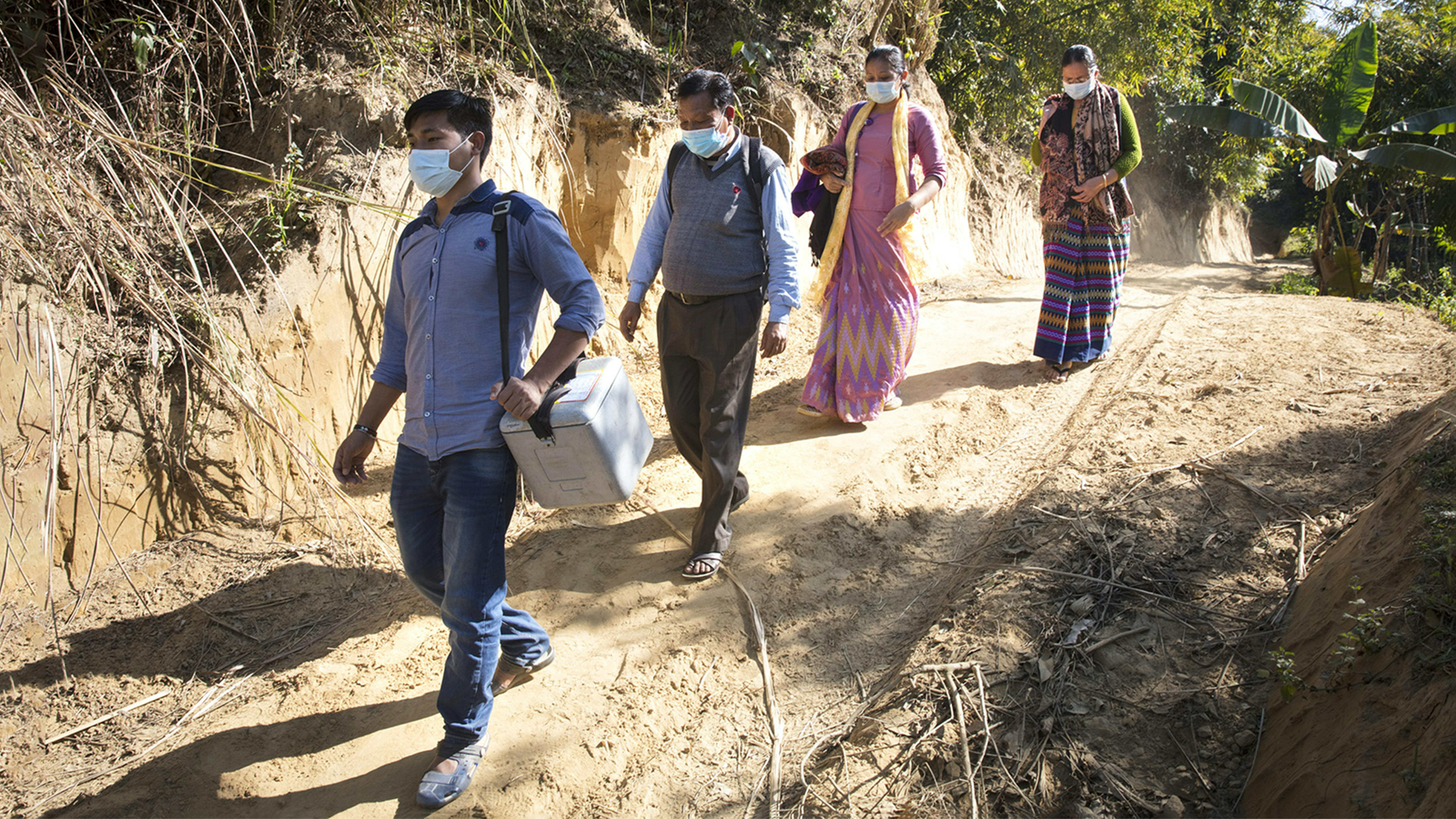 Yochingnu e il resto dello staff trasportano a piedi i vaccini nella zona di Rangamati, in Bangladesh.