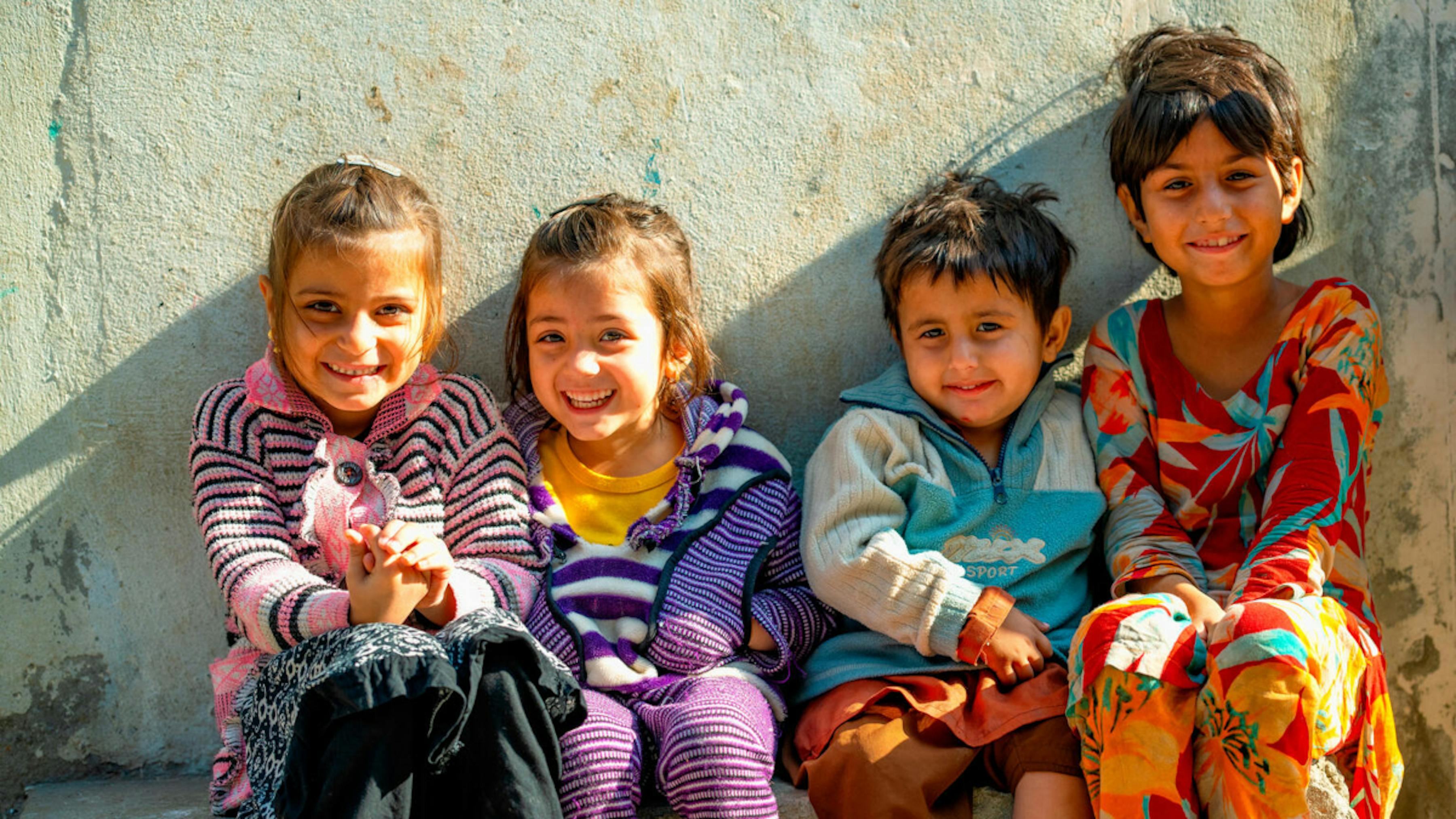 I bambini di Lahore, in Pakistan, accolgono con grandi sorrisi il team di vaccinazione antipolio.